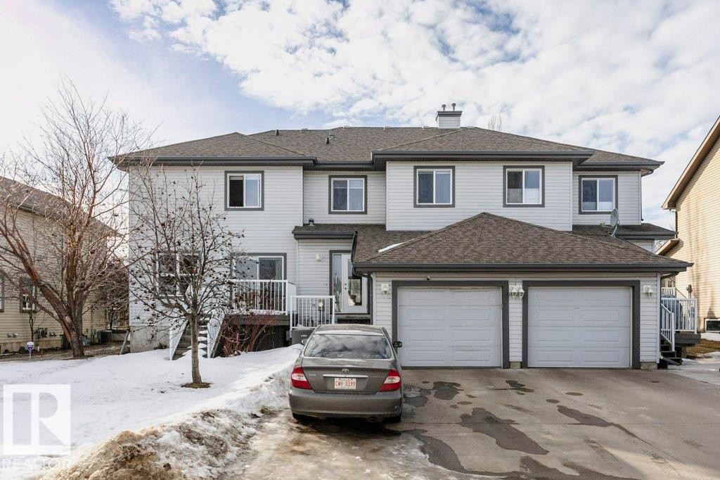 Traditional-style home with a shingled roof, a chimney, a garage, and asphalt driveway - 1381 Rutherford Road, Edmonton, AB - Outdoor With Facade