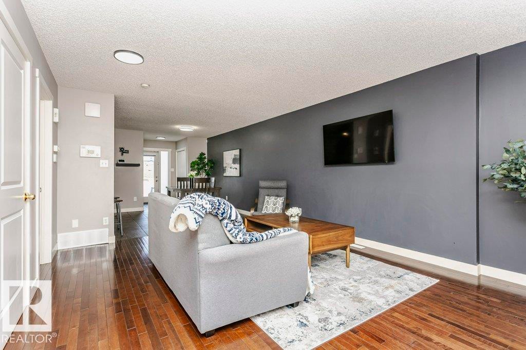Living area with dark wood finished floors and a textured ceiling - 1381 Rutherford Road, Edmonton, AB - Indoor Photo Showing Living Room