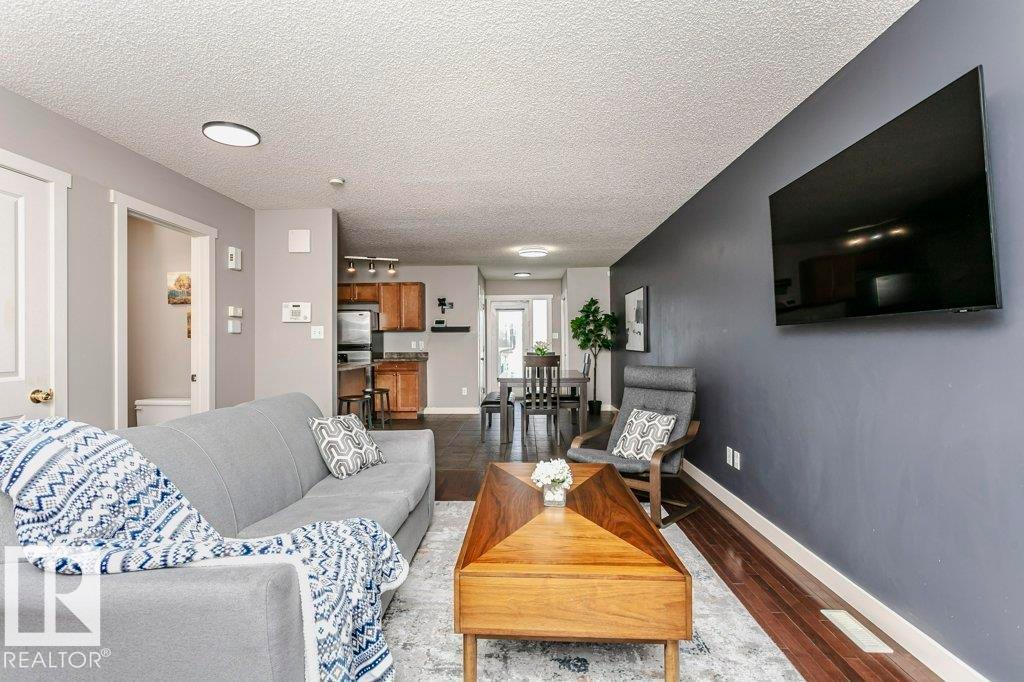 Living room with wood finished floors and a textured ceiling - 1381 Rutherford Road, Edmonton, AB - Indoor Photo Showing Living Room