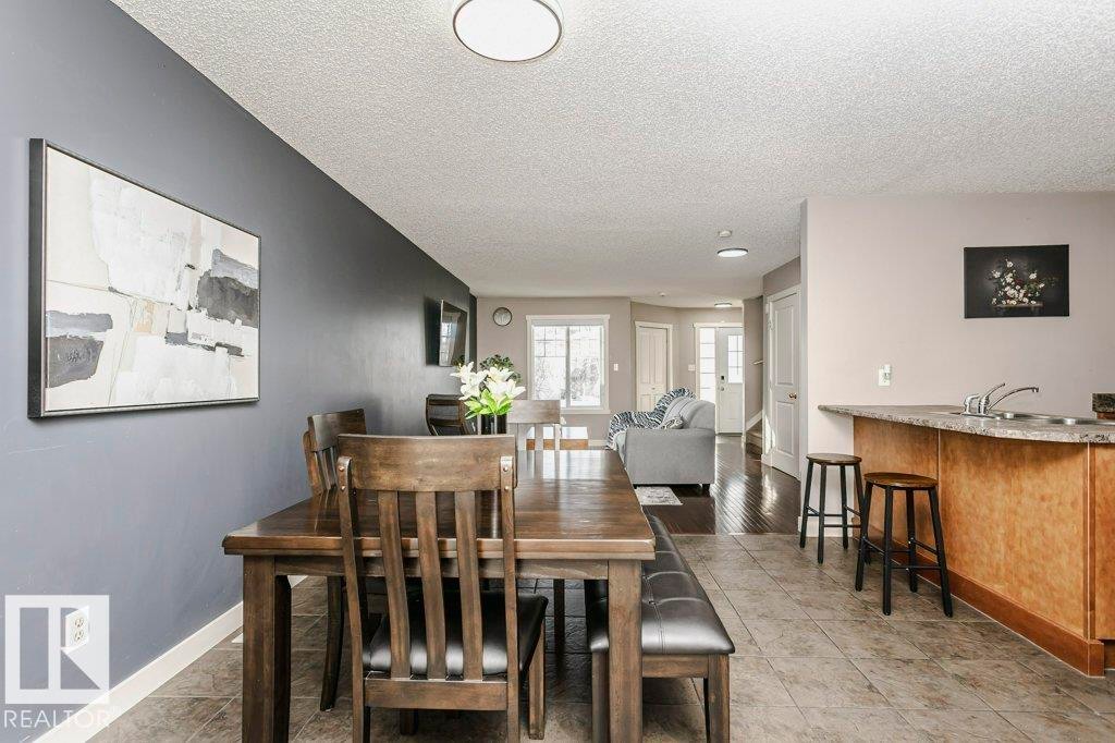 Dining space featuring a textured ceiling and light tile patterned floors - 1381 Rutherford Road, Edmonton, AB - Indoor Photo Showing Dining Room