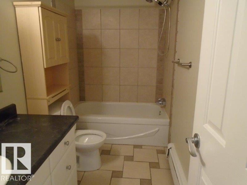 Full bath with vanity, shower / bathtub combination, baseboard heating, and light floors - 3041 Tudor Glen, St. Albert, AB