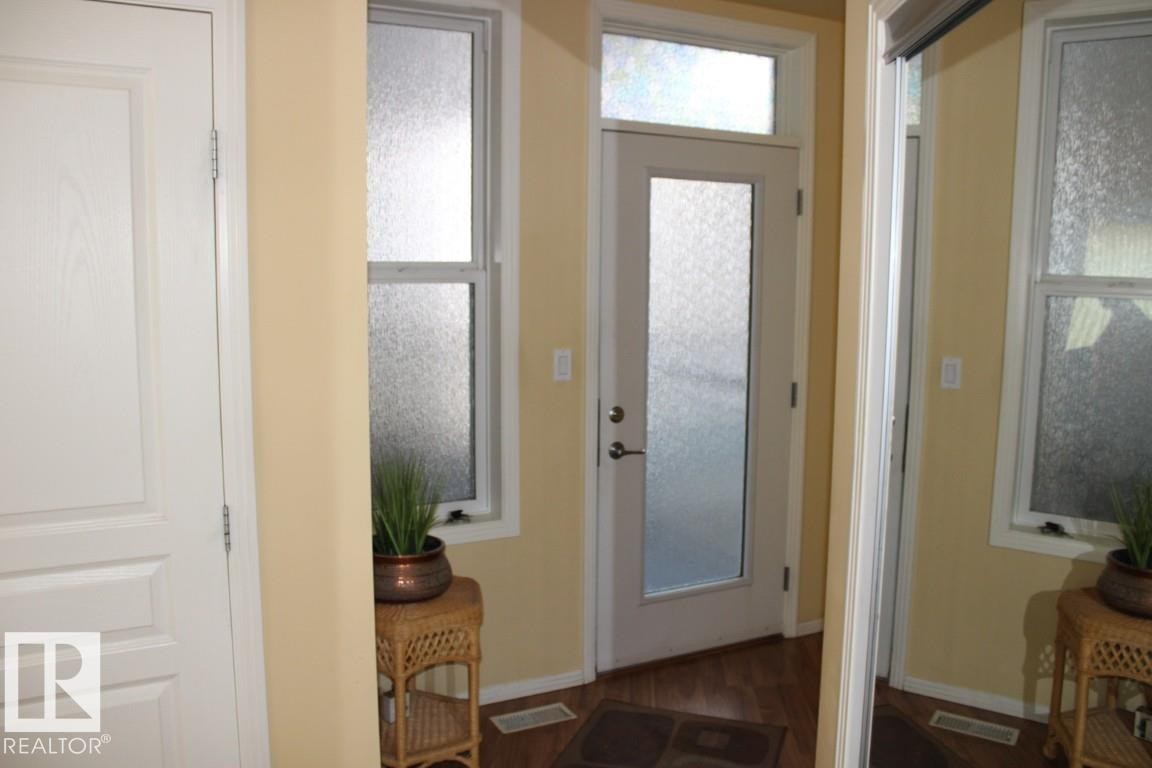 Foyer entrance featuring dark laminate flooring and baseboards - #330 4831 104A St Nw, Edmonton, AB - Indoor Photo Showing Other Room