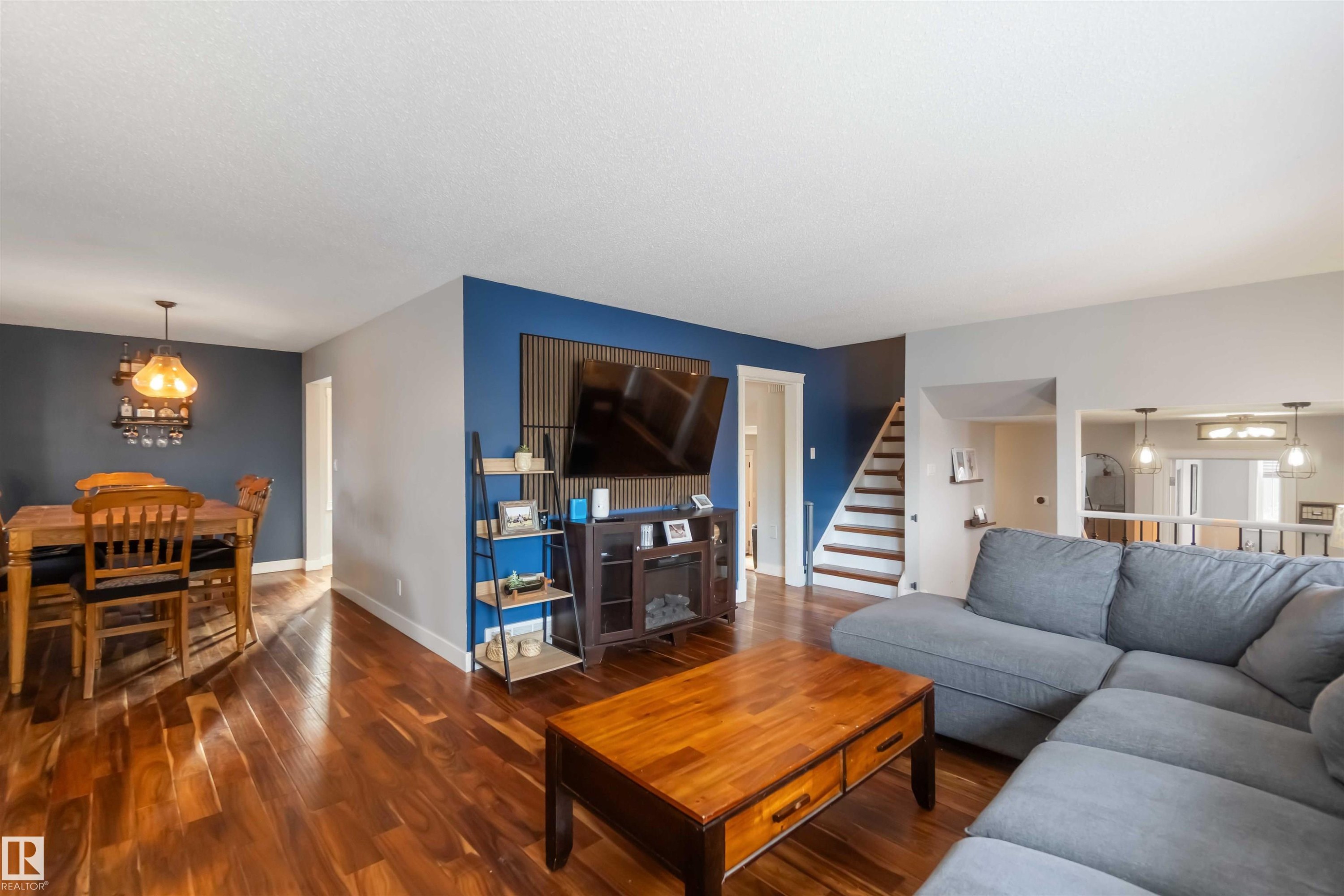 Living room with suspended lighting and wood finished floors - 6 Garraway Pl, St. Albert, AB - Indoor Photo Showing Living Room