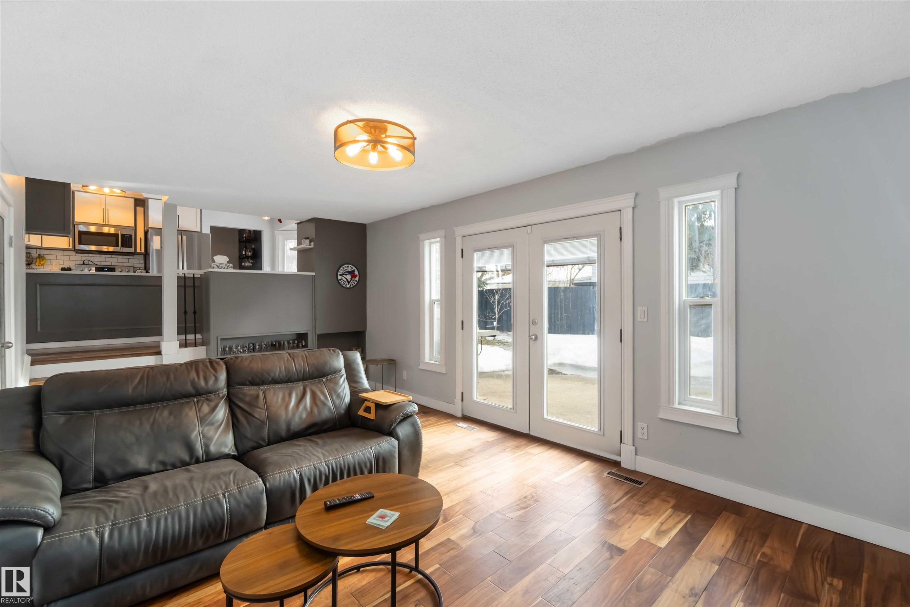 Living area with french doors, hardwood / wood-style flooring, and healthy amount of natural light - 6 Garraway Pl, St. Albert, AB - Indoor Photo Showing Living Room