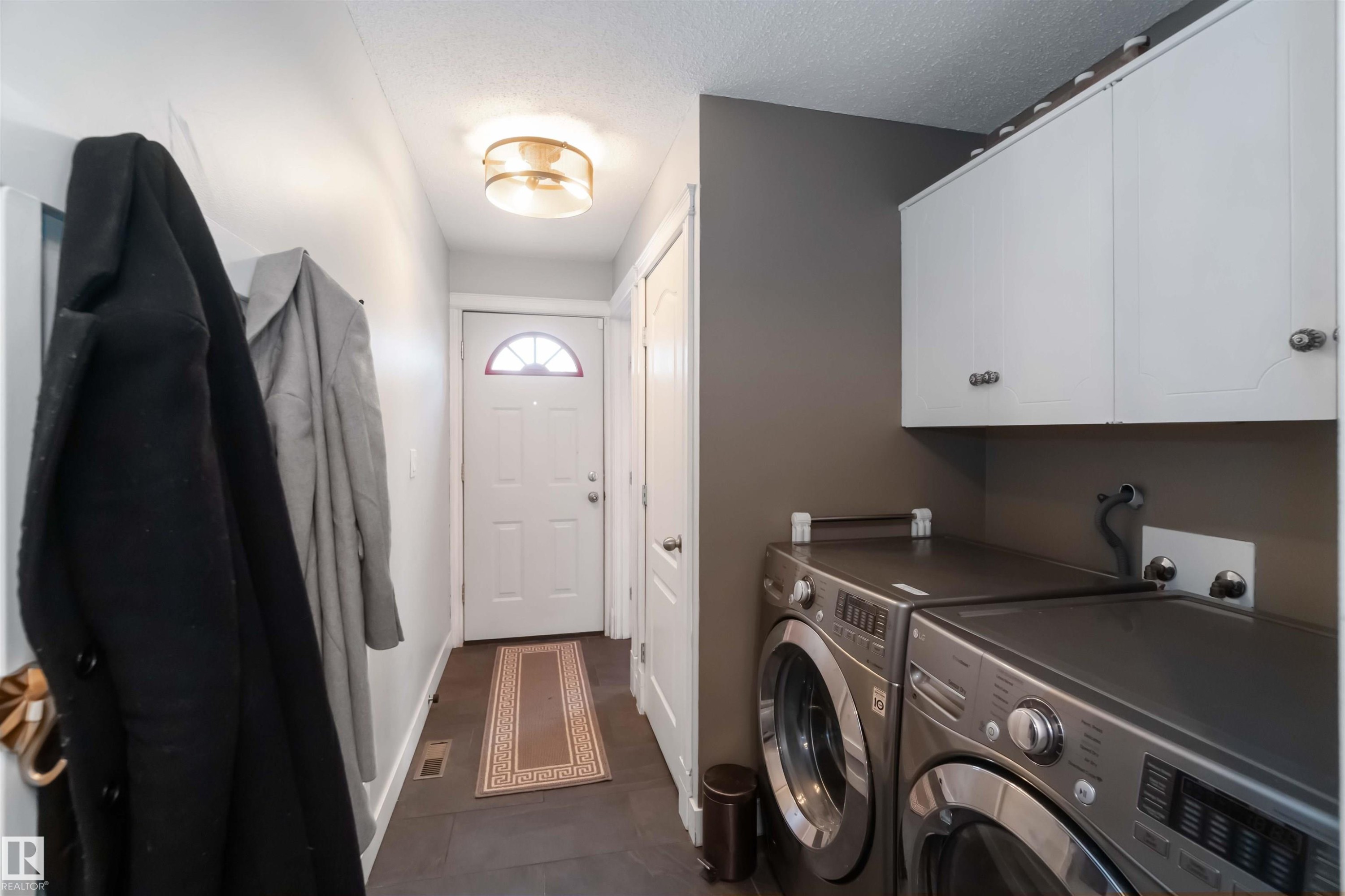 Laundry area with independent washer and dryer, cabinet space, and a textured ceiling - 6 Garraway Pl, St. Albert, AB - Indoor Photo Showing Laundry Room