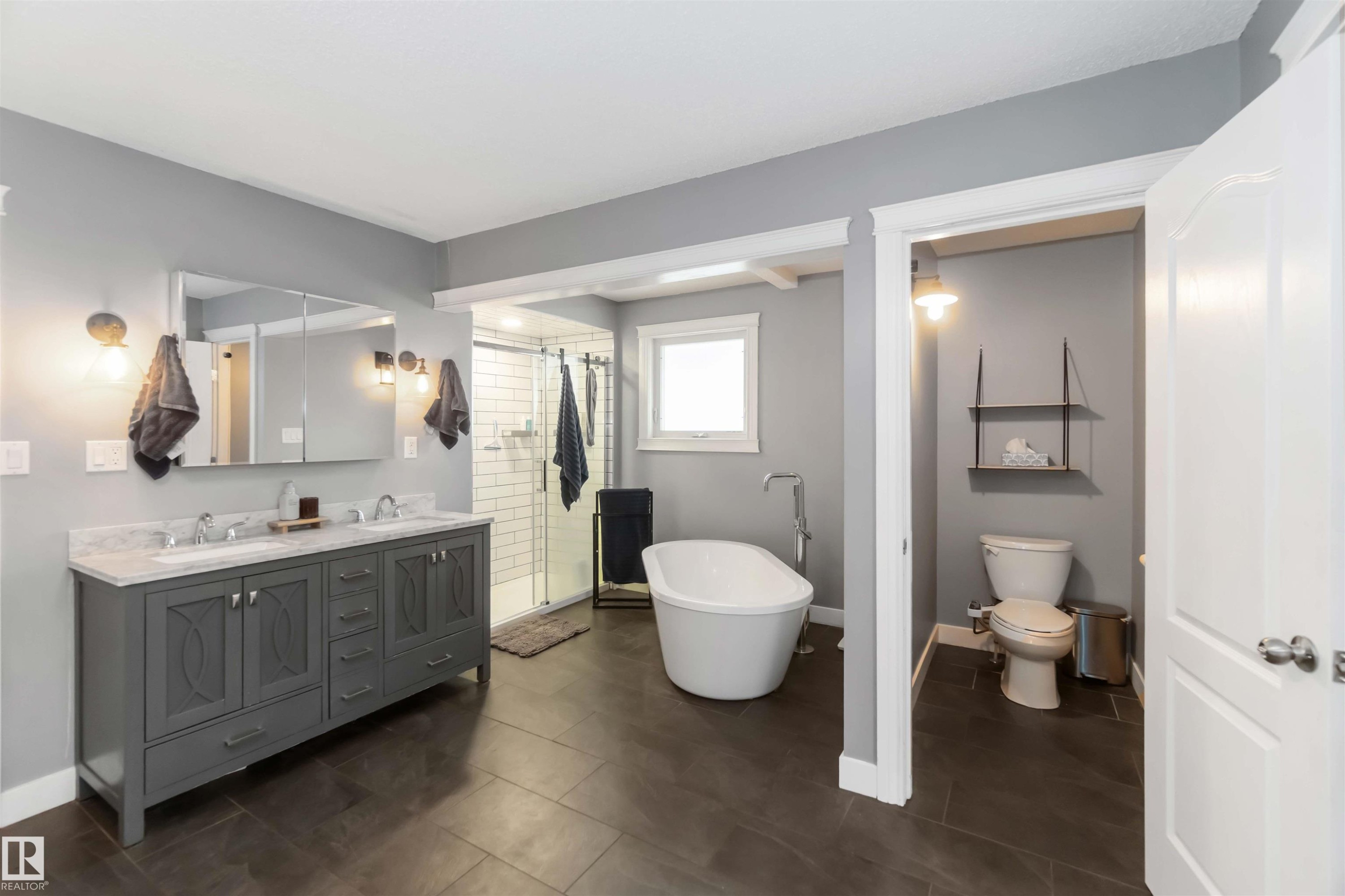Bathroom with double vanity, a stall shower, a freestanding bath, and dark tile patterned floors - 6 Garraway Pl, St. Albert, AB - Indoor Photo Showing Bathroom