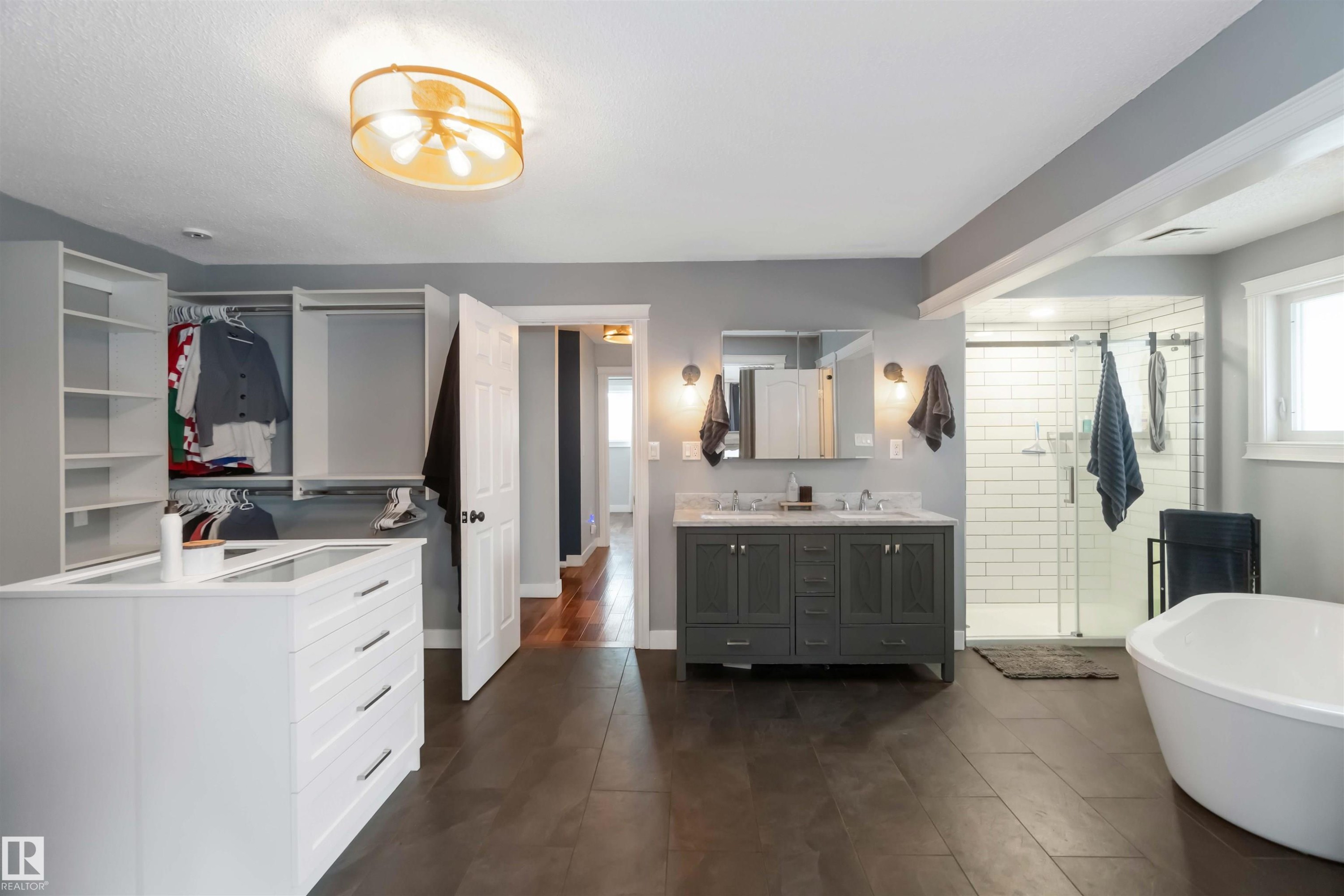 Full bathroom with double vanity, a shower stall, a walk in closet, and a freestanding tub - 6 Garraway Pl, St. Albert, AB - Indoor Photo Showing Bathroom