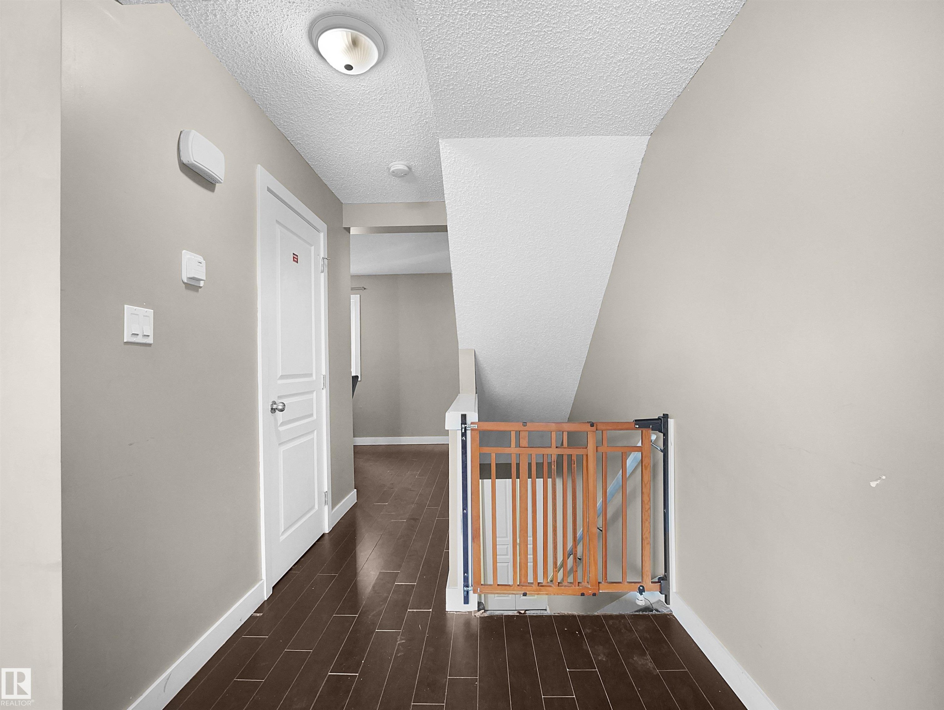 Hall featuring an upstairs landing, dark wood-style flooring, and a textured ceiling - 791 Abbottsfield Road, Edmonton, AB - Indoor Photo Showing Other Room