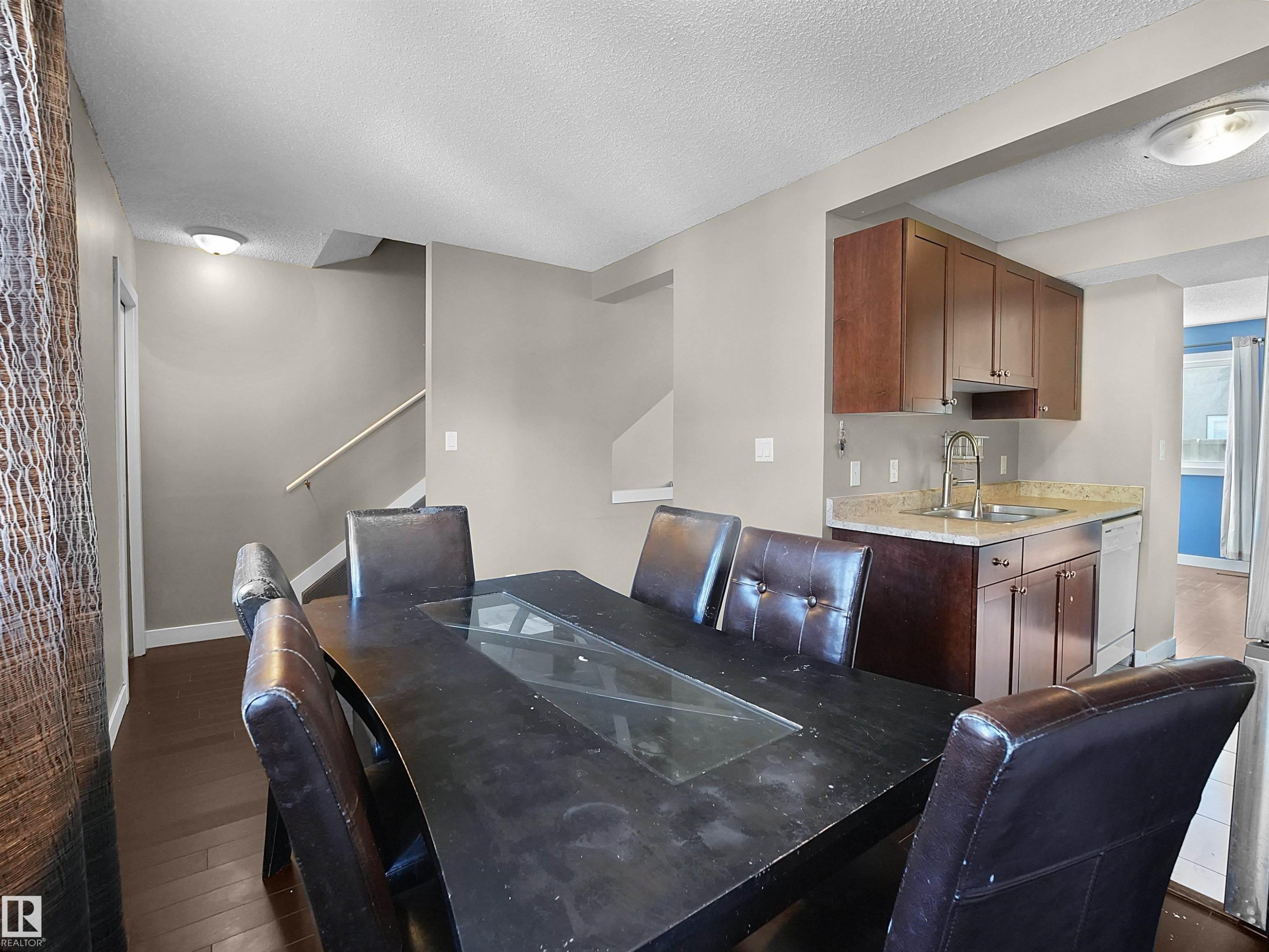 Dining space featuring a textured ceiling, dark wood finished floors, and stairway - 791 Abbottsfield Road, Edmonton, AB - Indoor