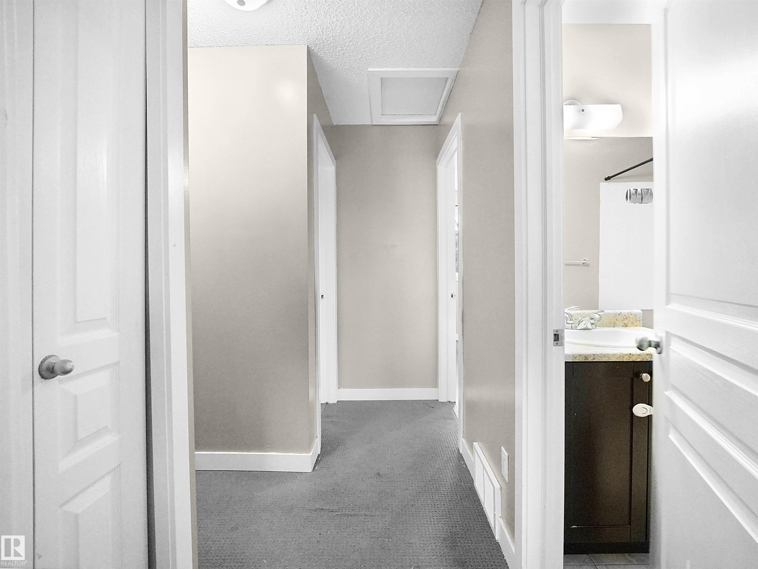 Hall with attic access, a textured ceiling, and carpet floors - 791 Abbottsfield Road, Edmonton, AB - Indoor Photo Showing Bathroom