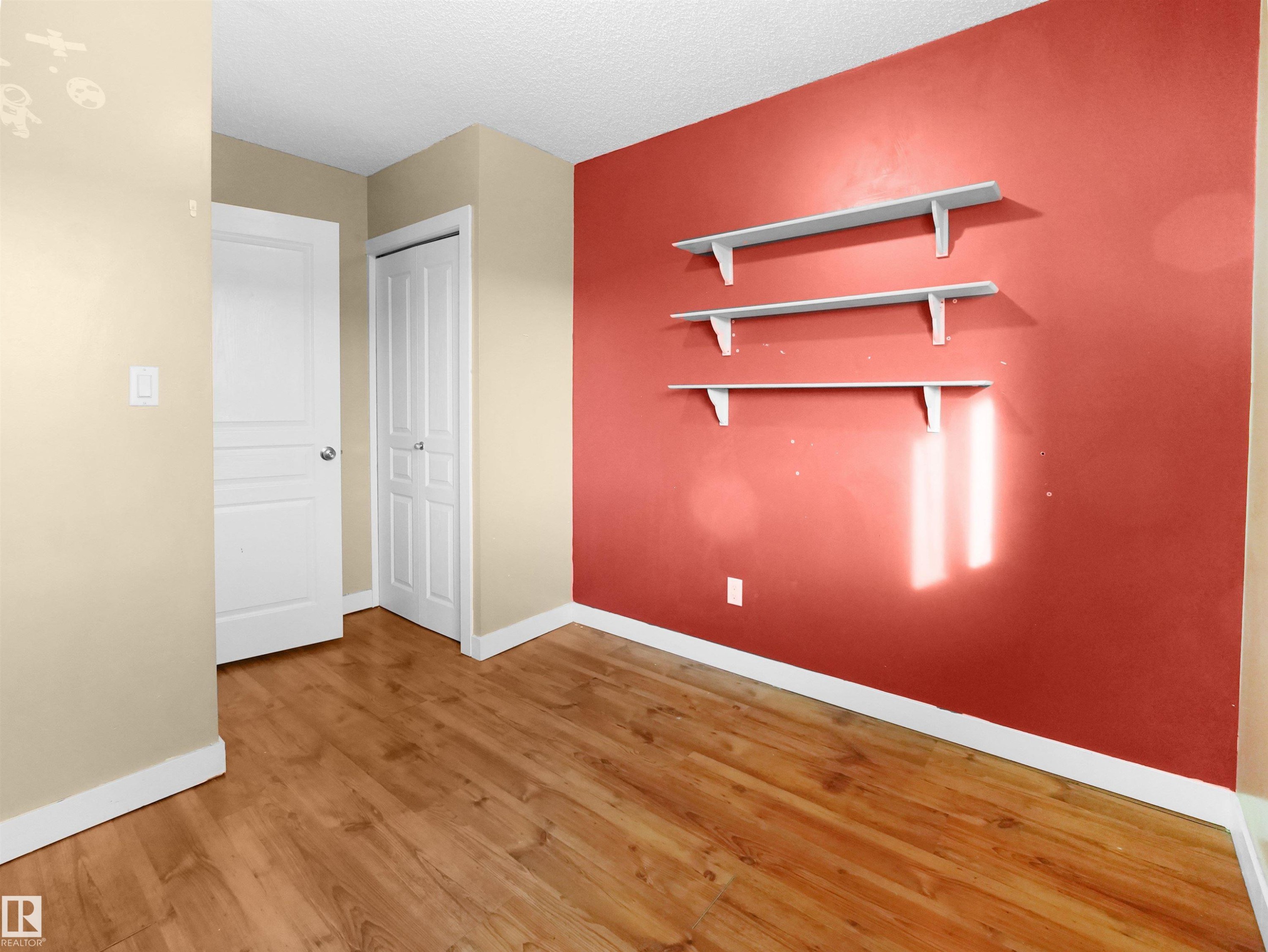 Unfurnished bedroom featuring light wood-style flooring, a textured ceiling, and a closet - 791 Abbottsfield Road, Edmonton, AB - Indoor Photo Showing Other Room