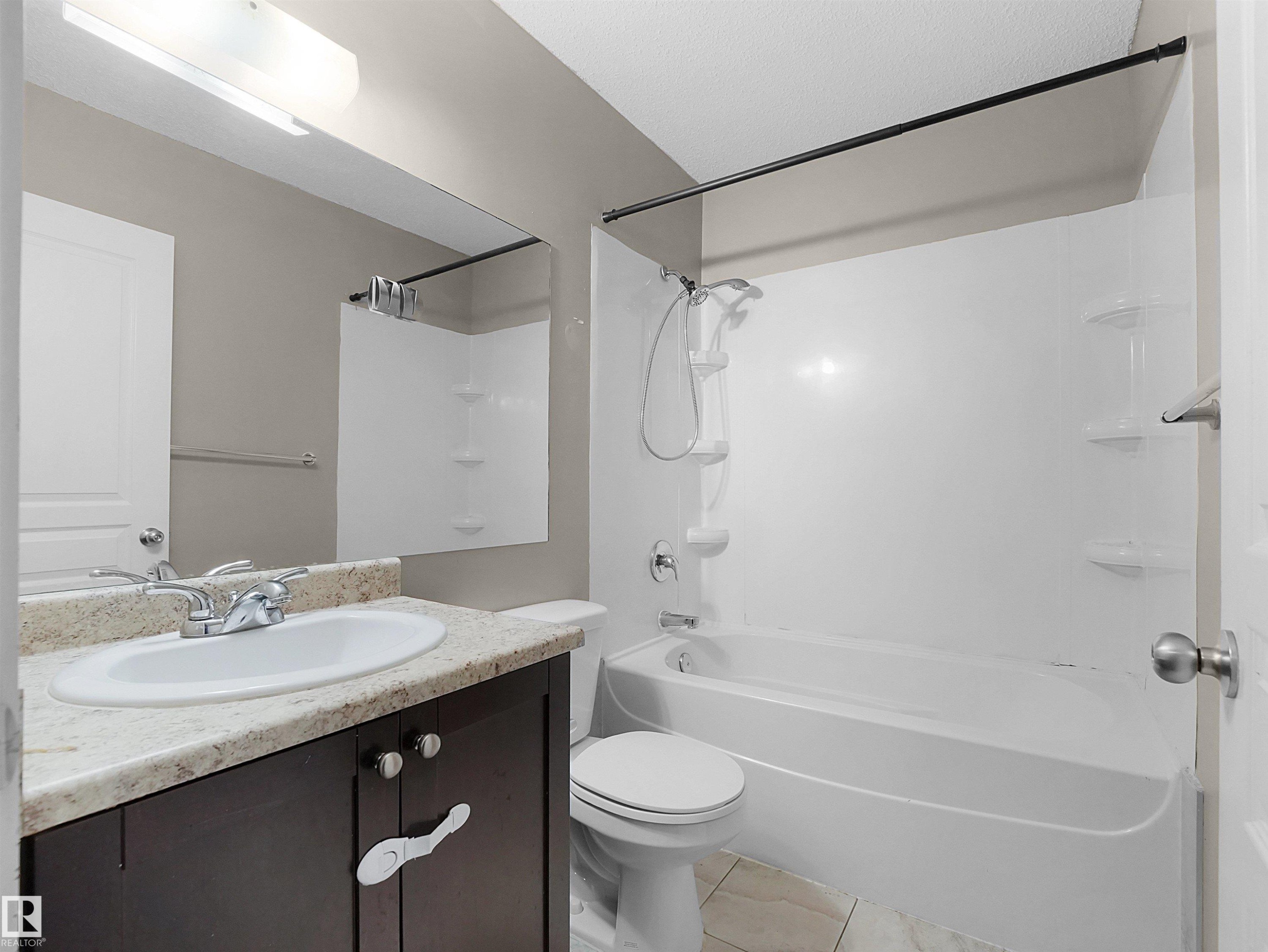 Full bath with vanity, tub / shower combination, and light tile patterned floors - 791 Abbottsfield Road, Edmonton, AB - Indoor Photo Showing Bathroom