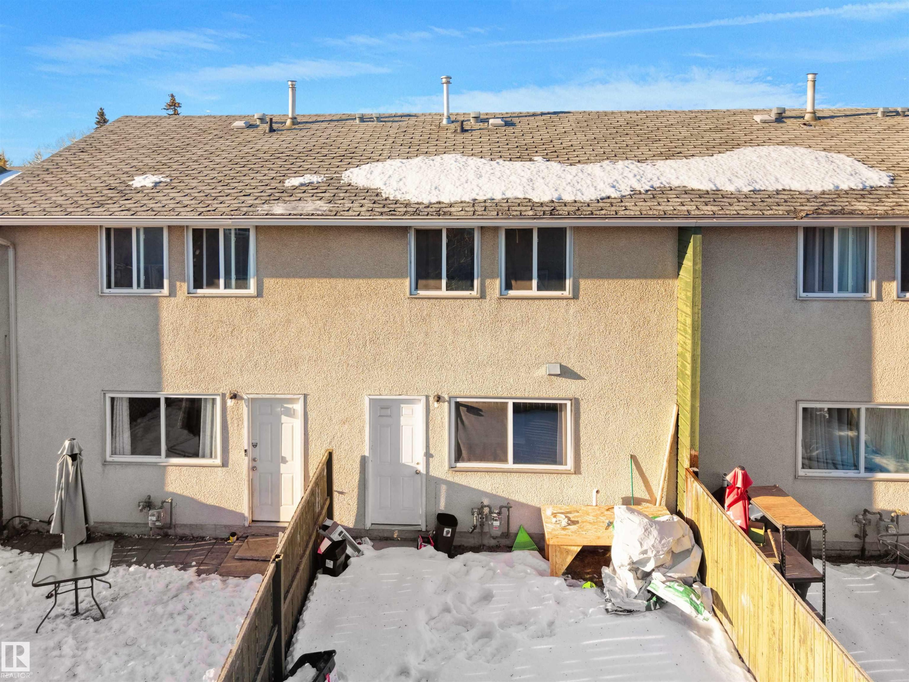 Rear view of property featuring stucco siding, a shingled roof, and a patio - 791 Abbottsfield Road, Edmonton, AB - Outdoor