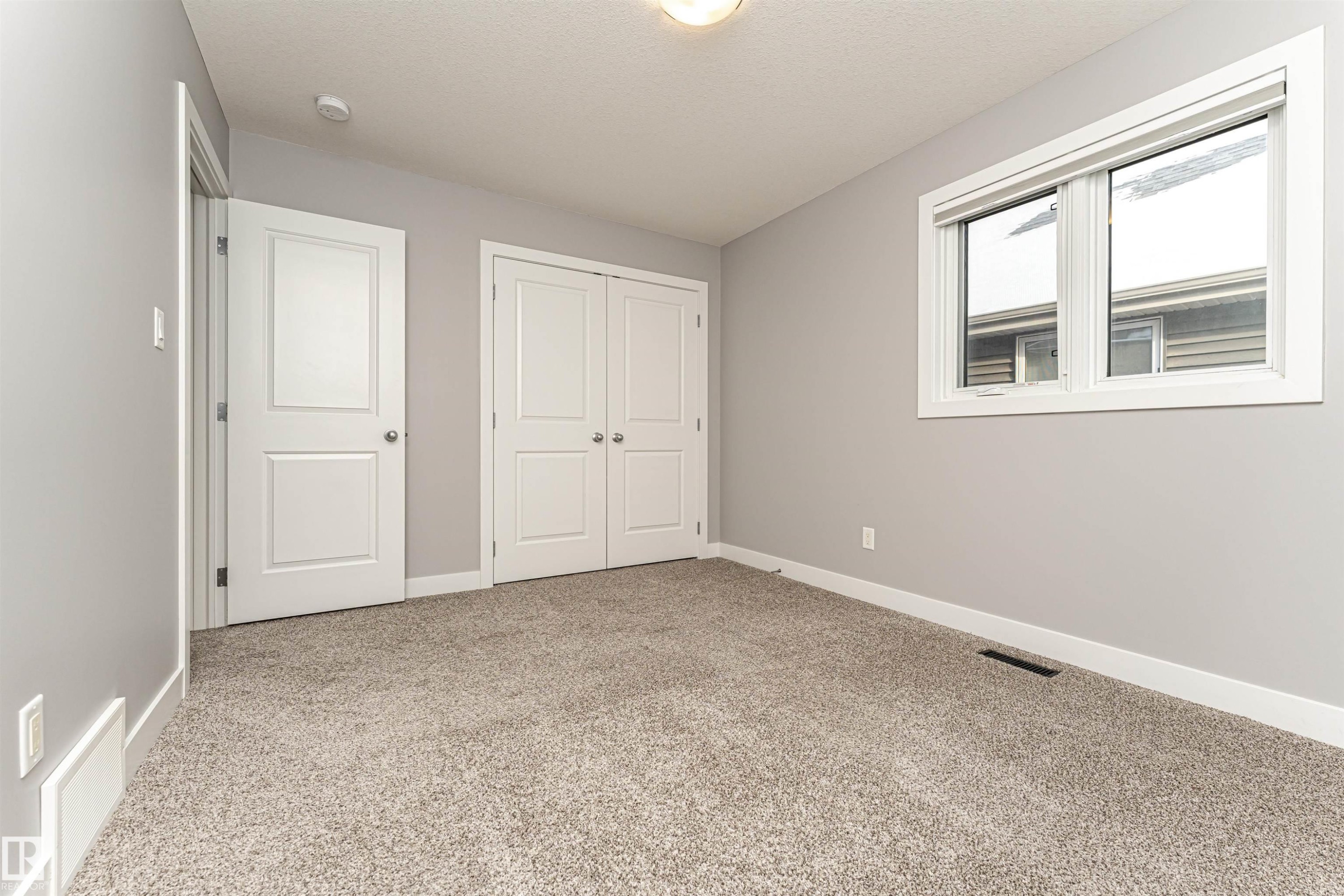 Unfurnished bedroom with light colored carpet and a closet - 3611 Keswick Boulevard, Edmonton, AB - Indoor Photo Showing Other Room