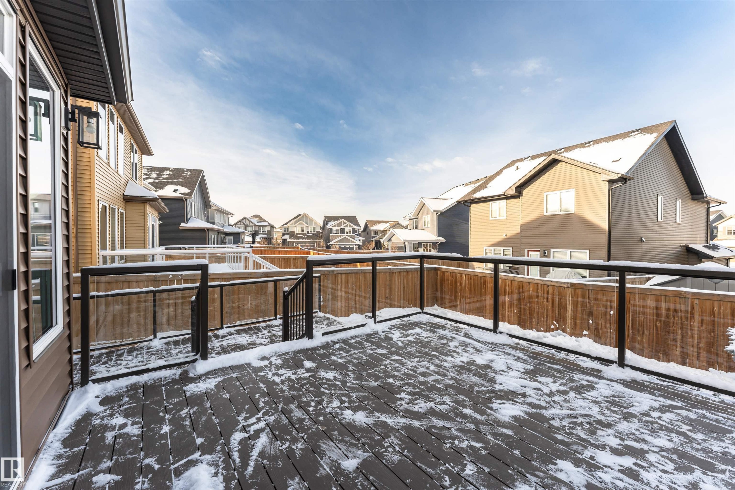 Snow covered patio with a residential view and a wooden deck - 3611 Keswick Boulevard, Edmonton, AB - Outdoor