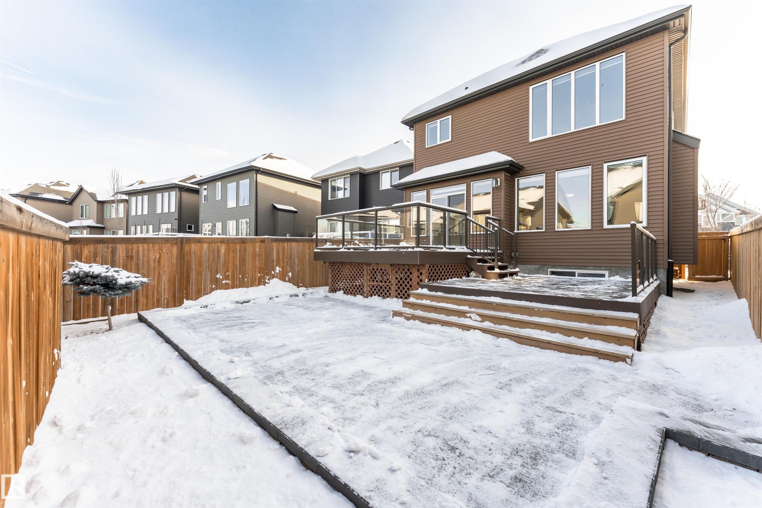 Snow covered property with a fenced backyard, a wooden deck, and a residential view - 3611 Keswick Boulevard, Edmonton, AB - Outdoor With Deck Patio Veranda With Exterior