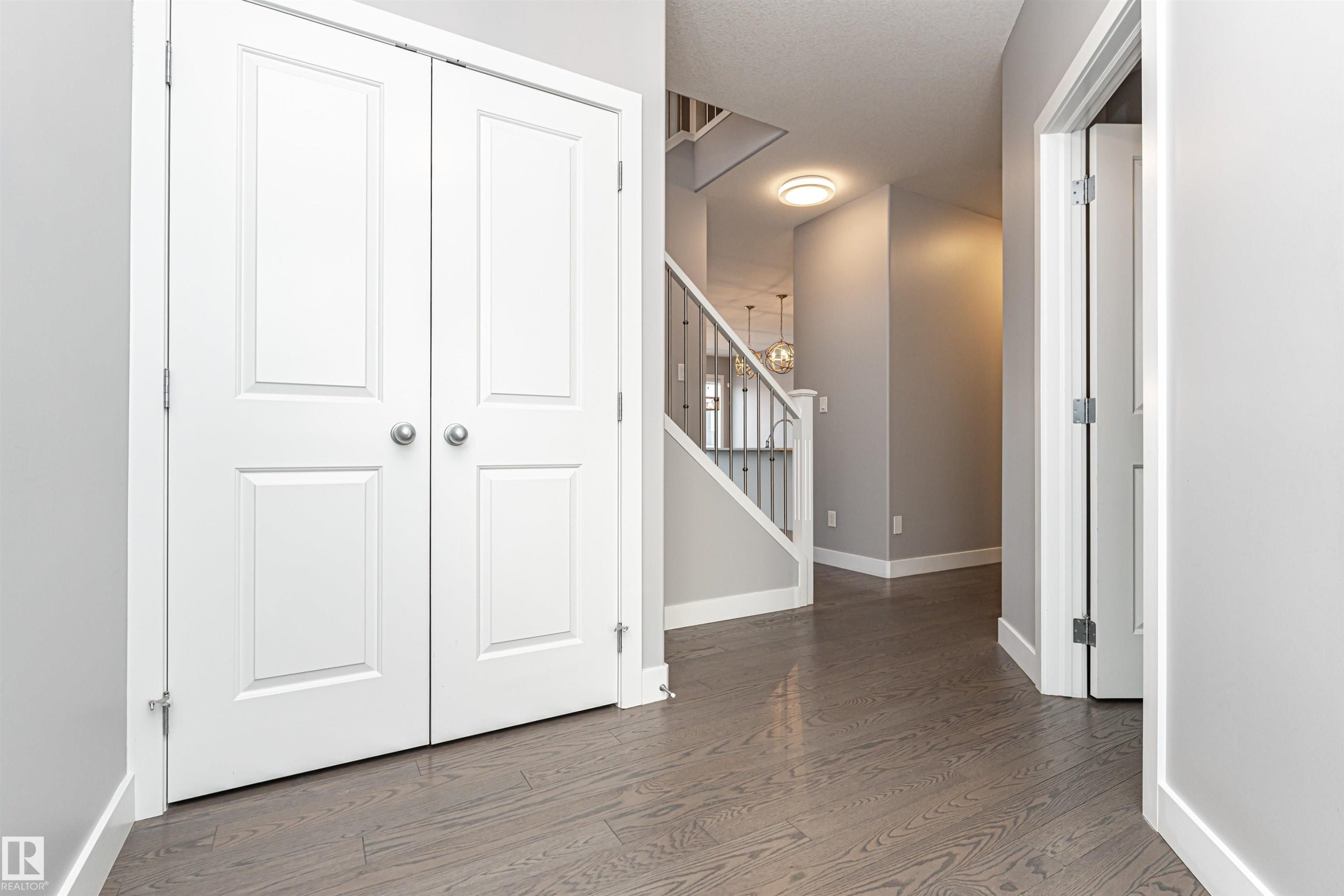 Hallway with stairway and wood finished floors - 3611 Keswick Boulevard, Edmonton, AB - Indoor Photo Showing Other Room
