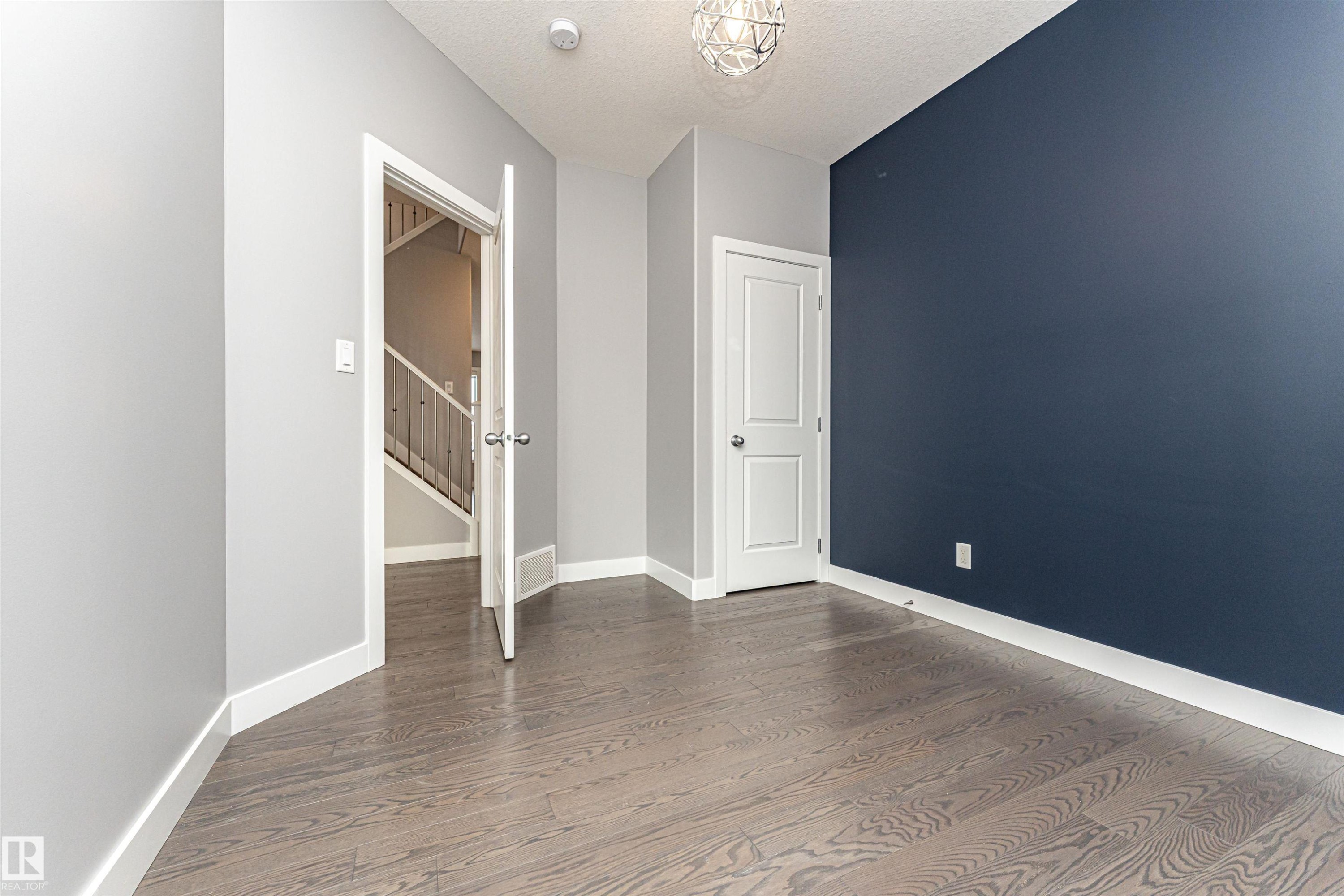 Unfurnished bedroom with wood finished floors and a textured ceiling - 3611 Keswick Boulevard, Edmonton, AB - Indoor Photo Showing Other Room