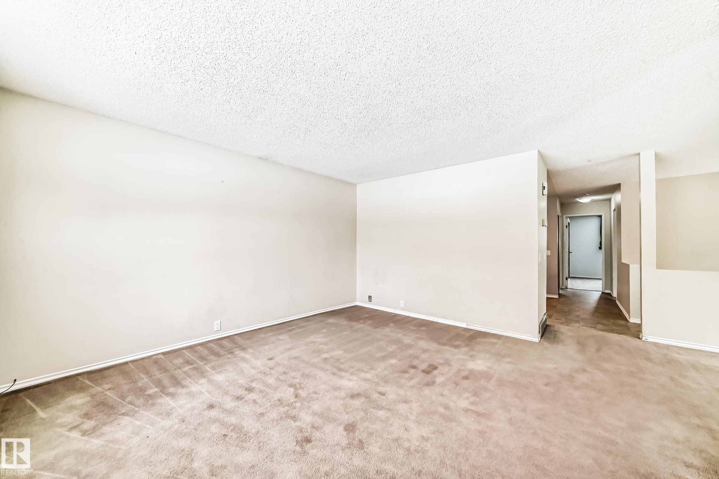 Empty room with light carpet and a textured ceiling - 5308 20 Avenue, Edmonton, AB - Indoor Photo Showing Other Room