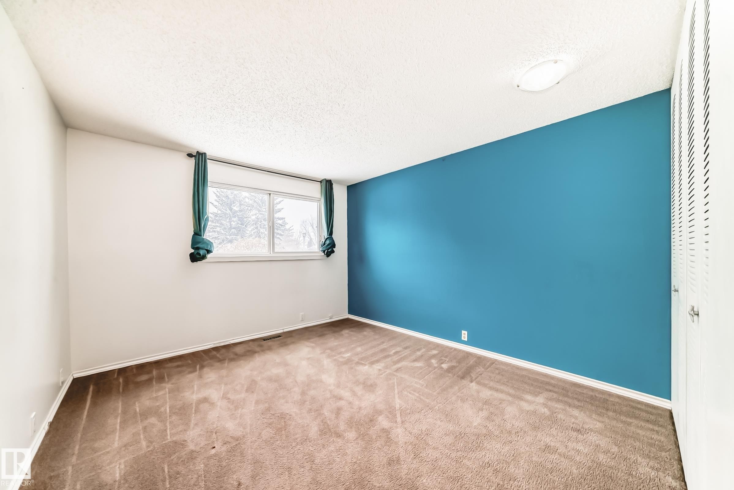 Carpeted empty room with a textured ceiling and baseboards - 5308 20 Avenue, Edmonton, AB - Indoor Photo Showing Other Room