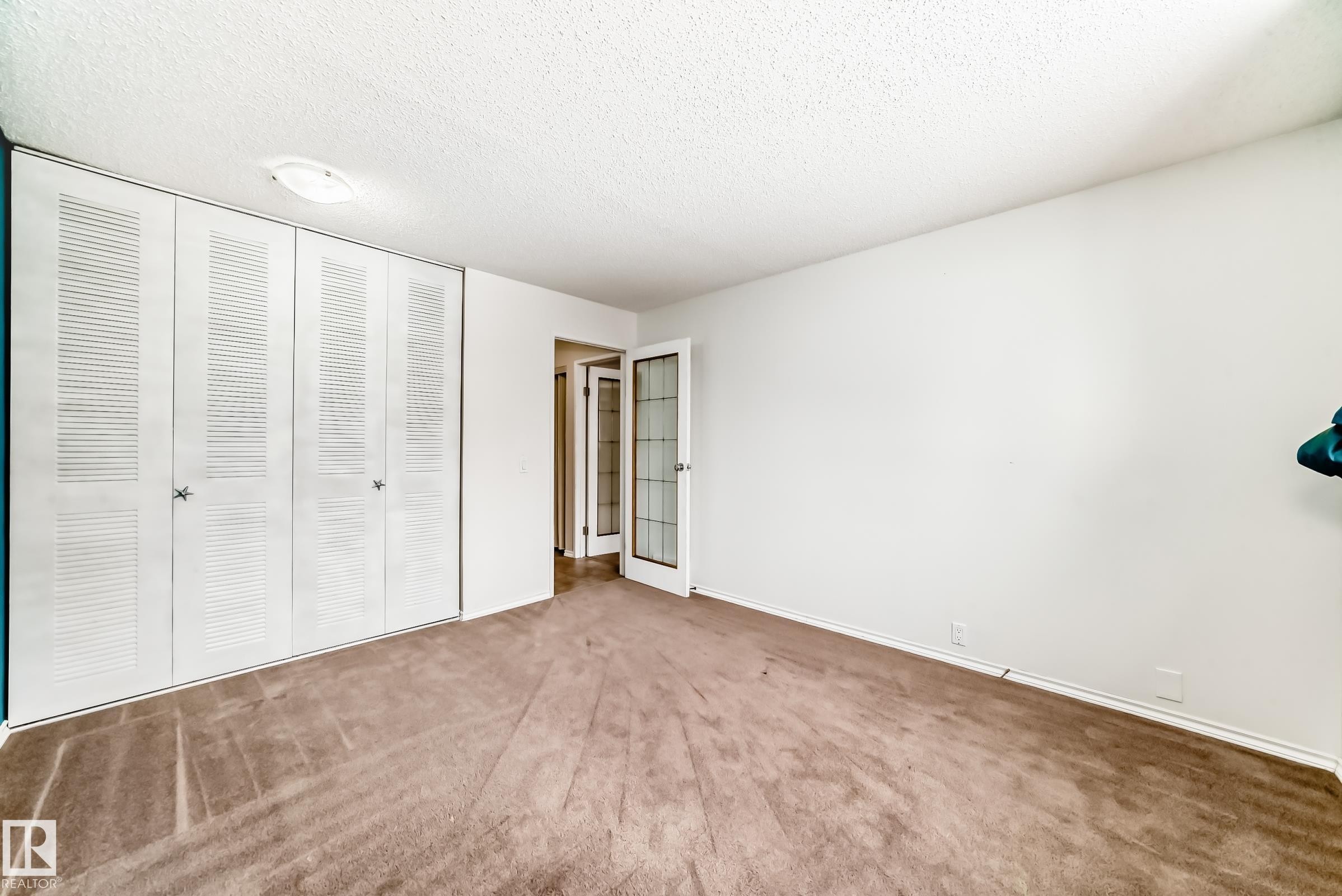 Unfurnished bedroom with carpet, a textured ceiling, and a closet - 5308 20 Avenue, Edmonton, AB - Indoor Photo Showing Other Room