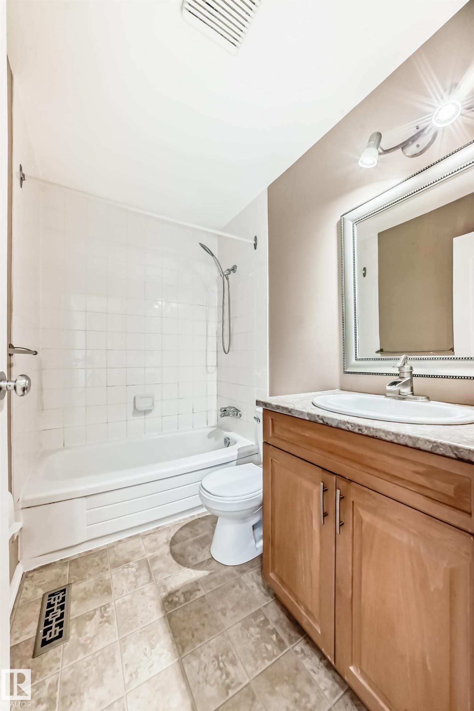 Full bathroom with shower combination, vanity, and light tile patterned flooring - 5308 20 Avenue, Edmonton, AB - Indoor Photo Showing Bathroom