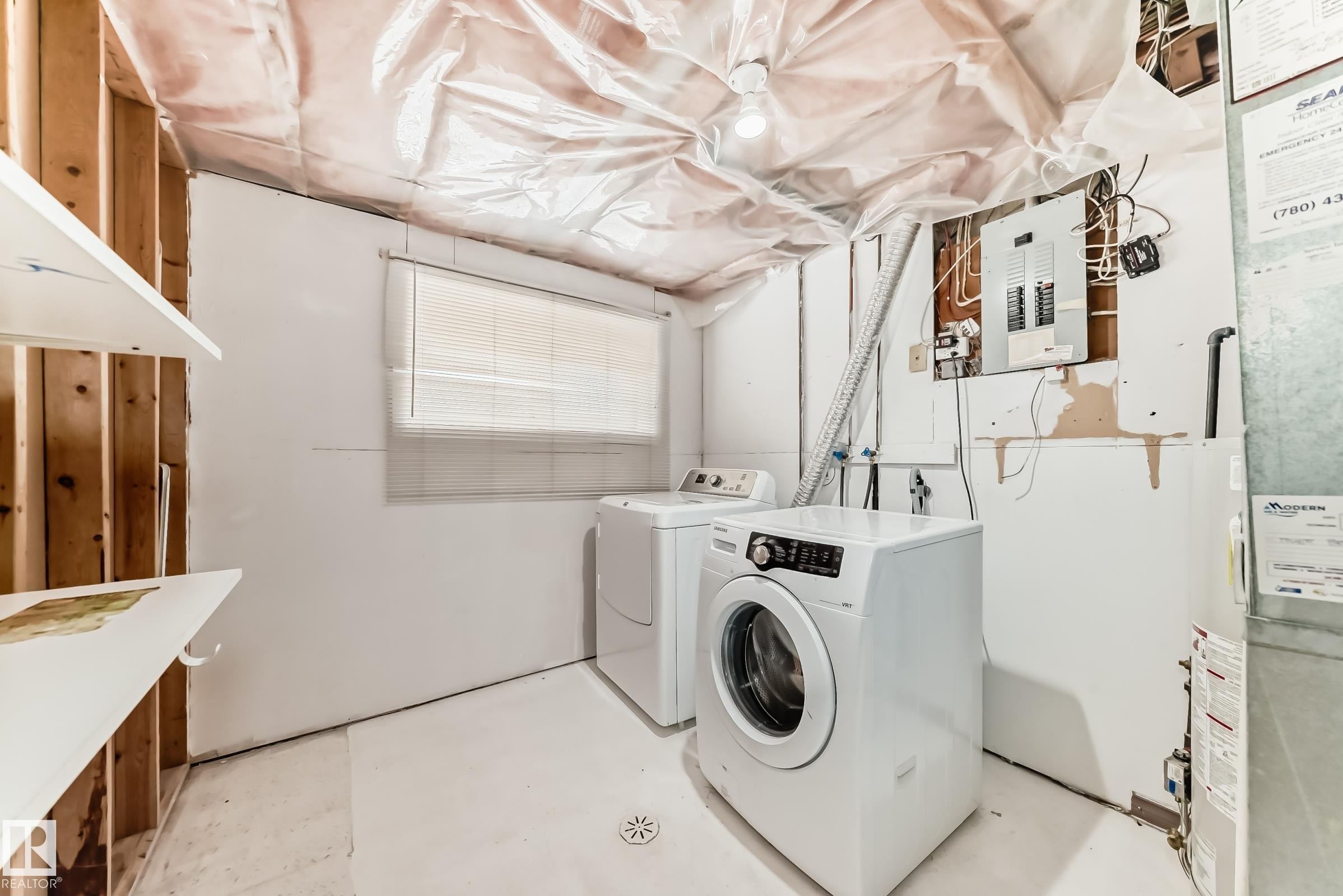 Laundry area featuring concrete flooring, washing machine and clothes dryer, electric panel, water heater, and heating unit - 5308 20 Avenue, Edmonton, AB - Indoor Photo Showing Laundry Room