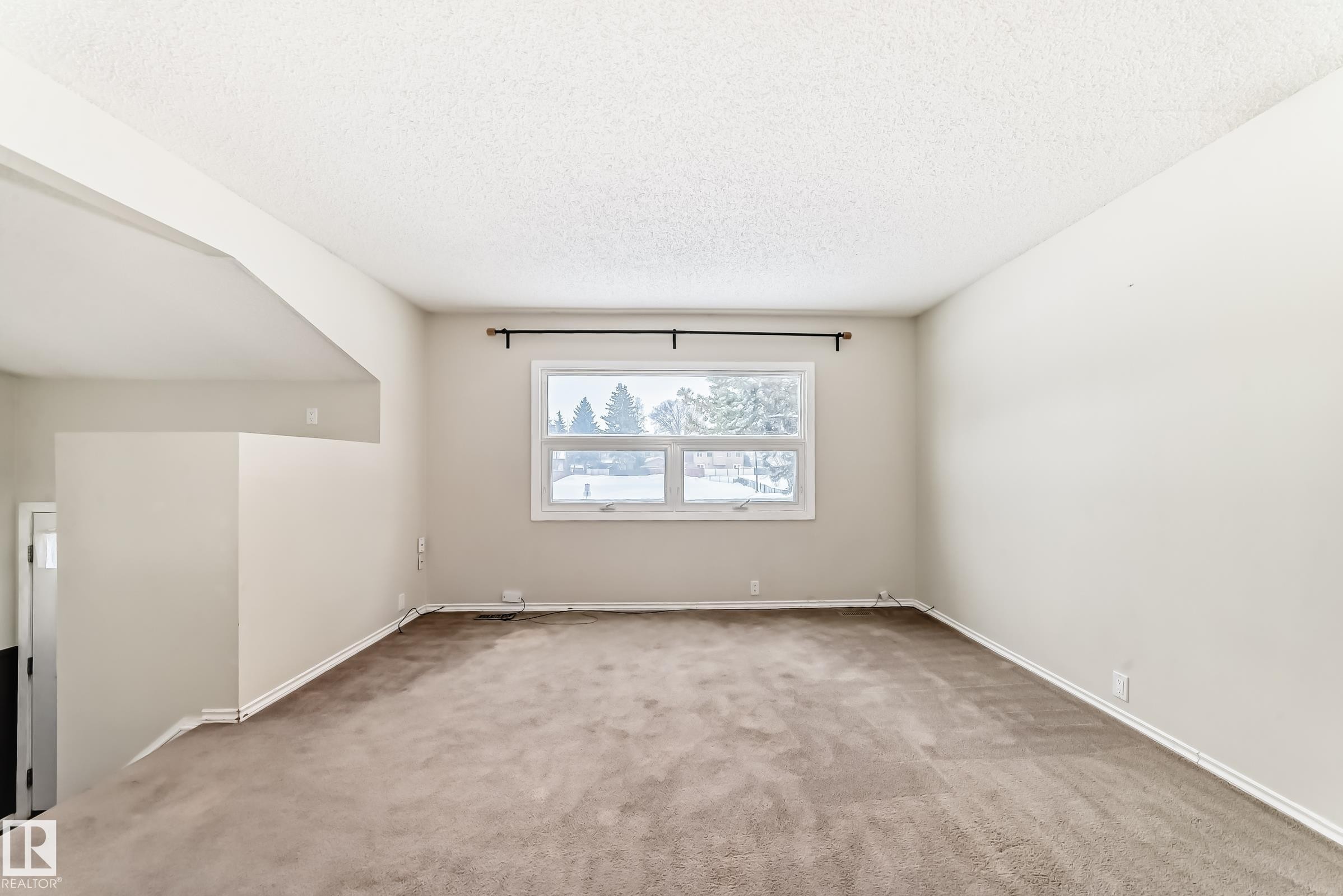 Unfurnished room featuring light carpet and a textured ceiling - 5308 20 Avenue, Edmonton, AB - Indoor Photo Showing Other Room