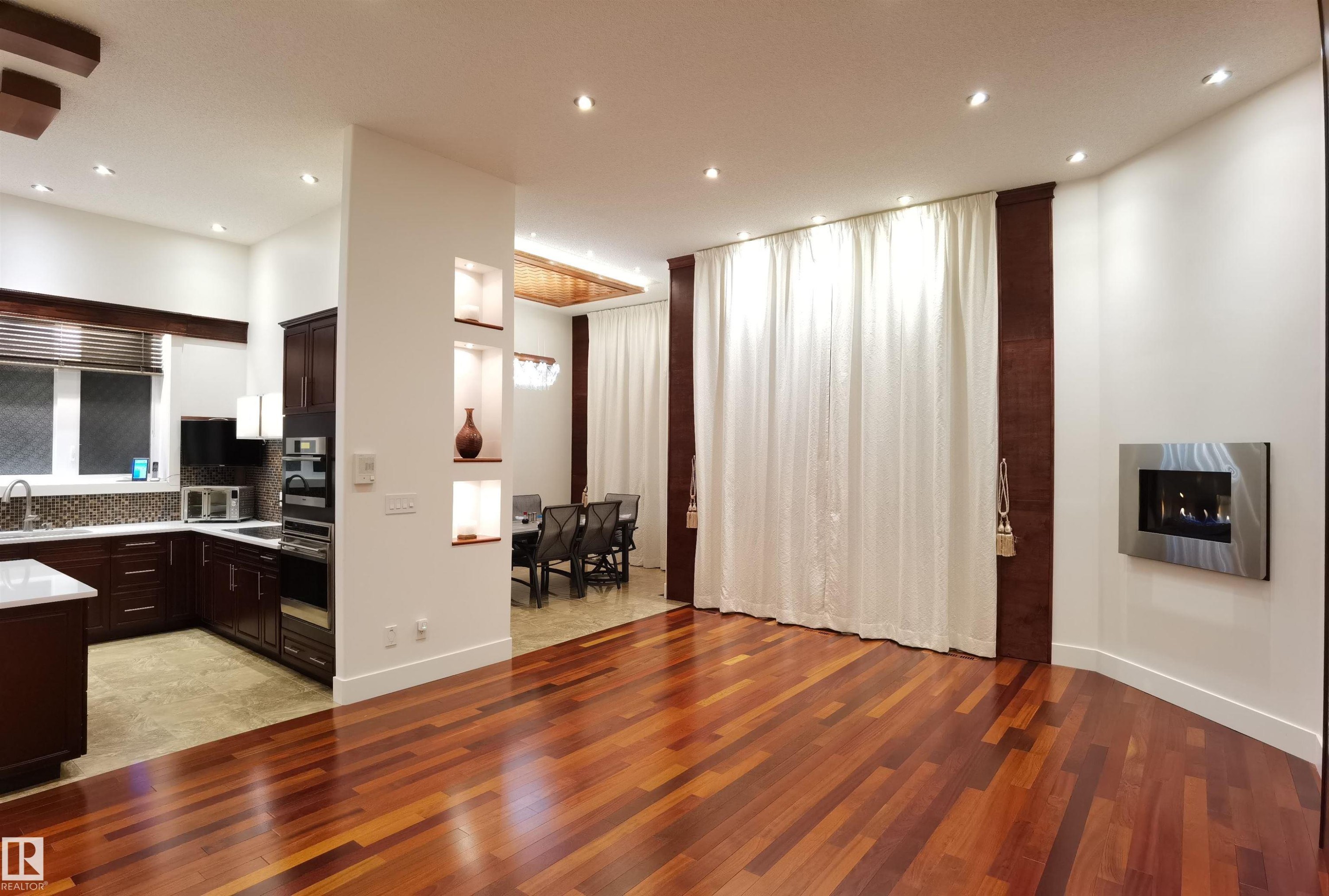 Kitchen featuring dark wood finish cabinetry, light wood finished floors, light stone counters, and recessed lighting - 169 Callaghan Drive, Edmonton, AB - Indoor