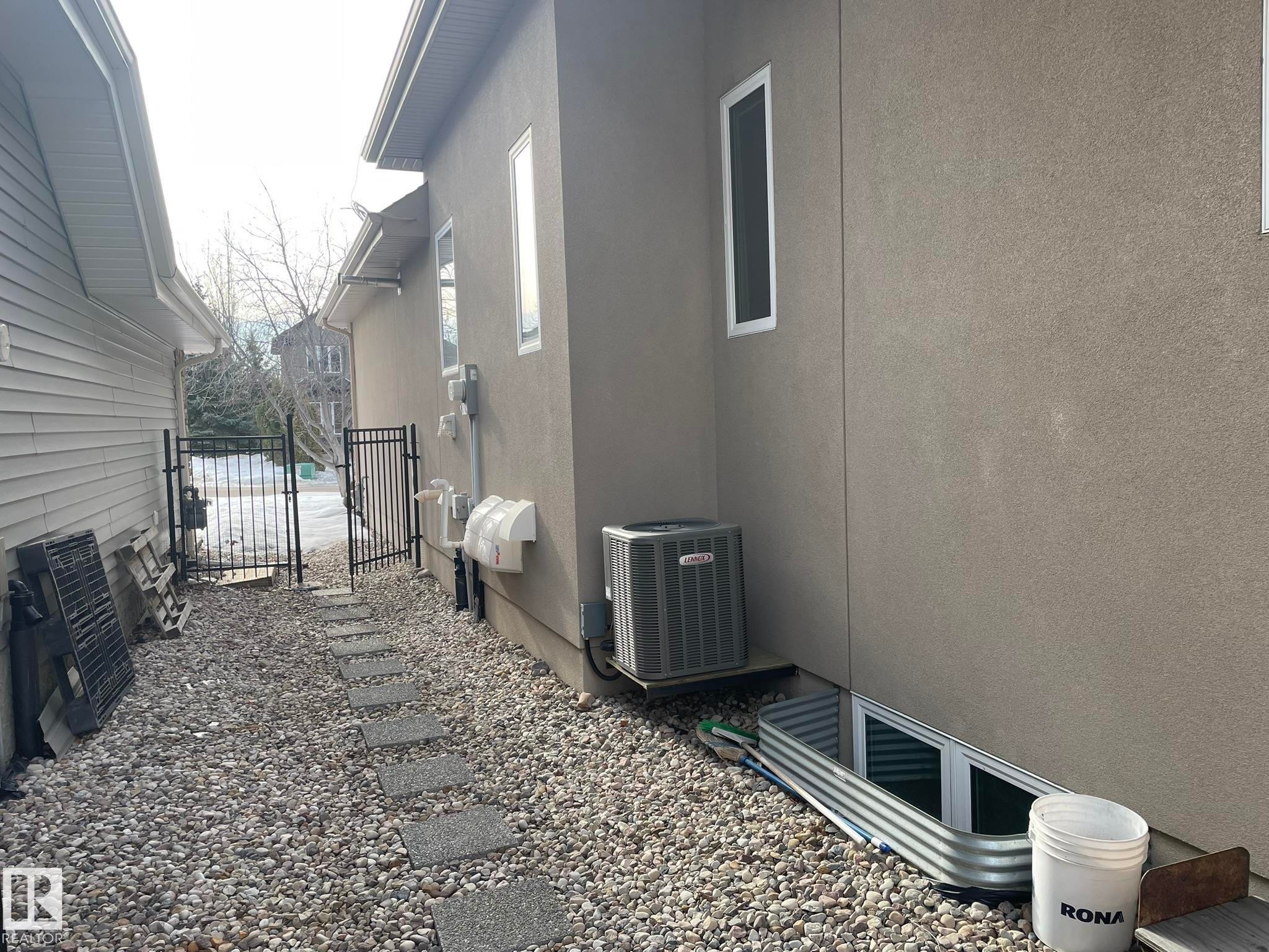 View of property exterior with a gate and stucco siding - 169 Callaghan Drive, Edmonton, AB - Outdoor With Exterior