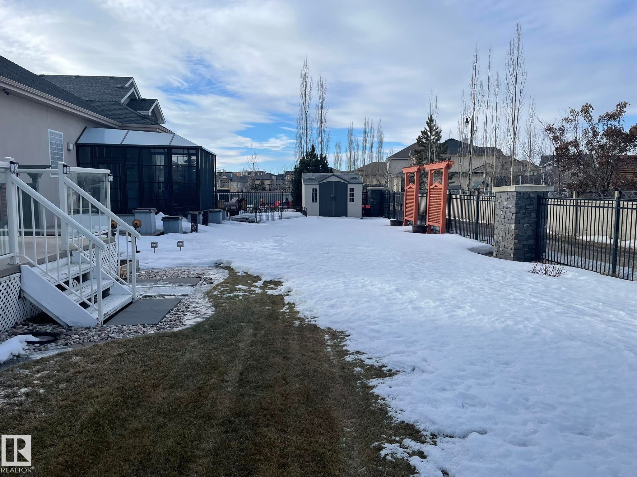 Yard layered in snow with a residential view, a shed, glass enclosure, and a sunroom - 169 Callaghan Drive, Edmonton, AB - Outdoor