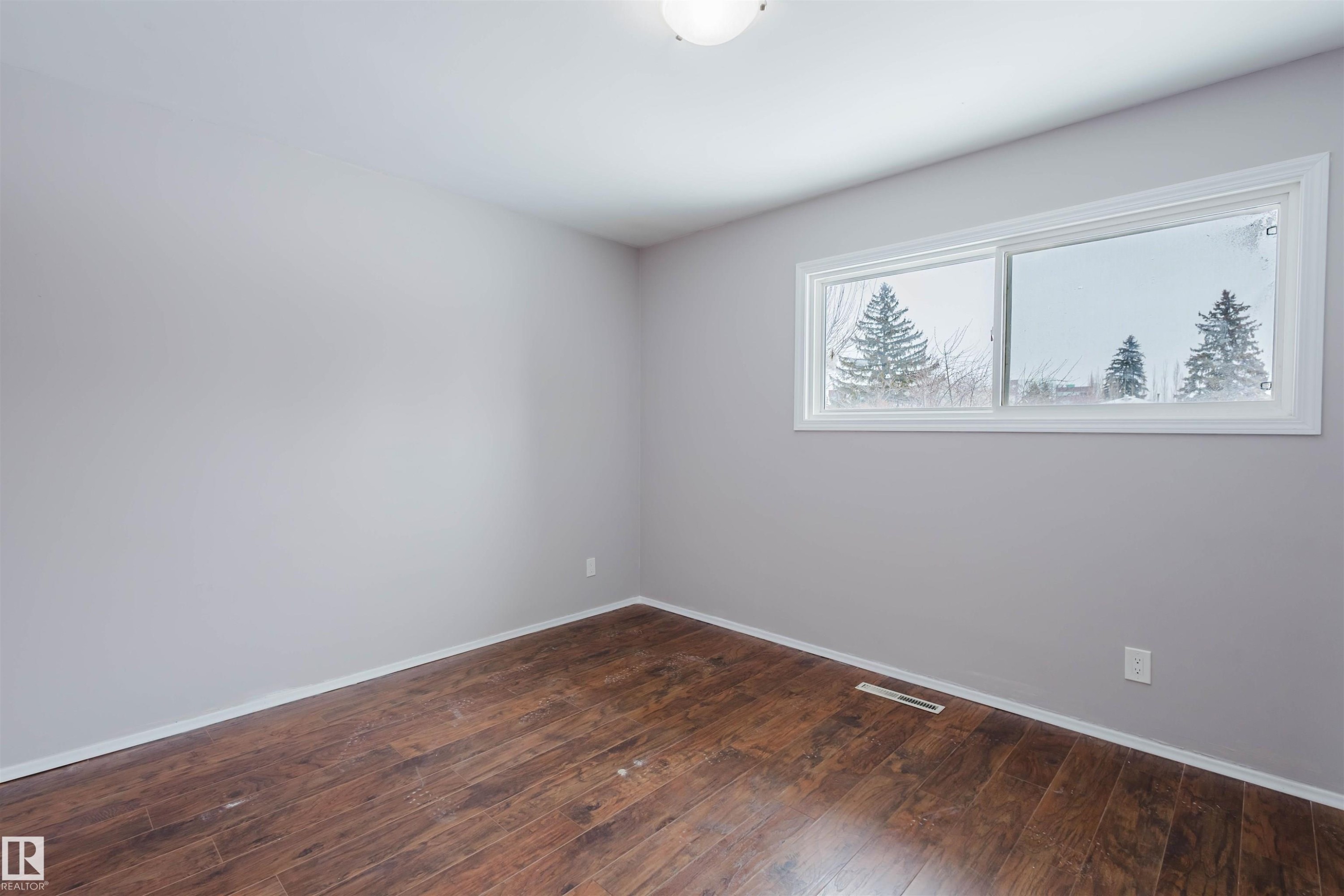 Unfurnished room with dark wood-style floors and baseboards - 6048 105B Street Nw, Edmonton, AB - Indoor Photo Showing Other Room
