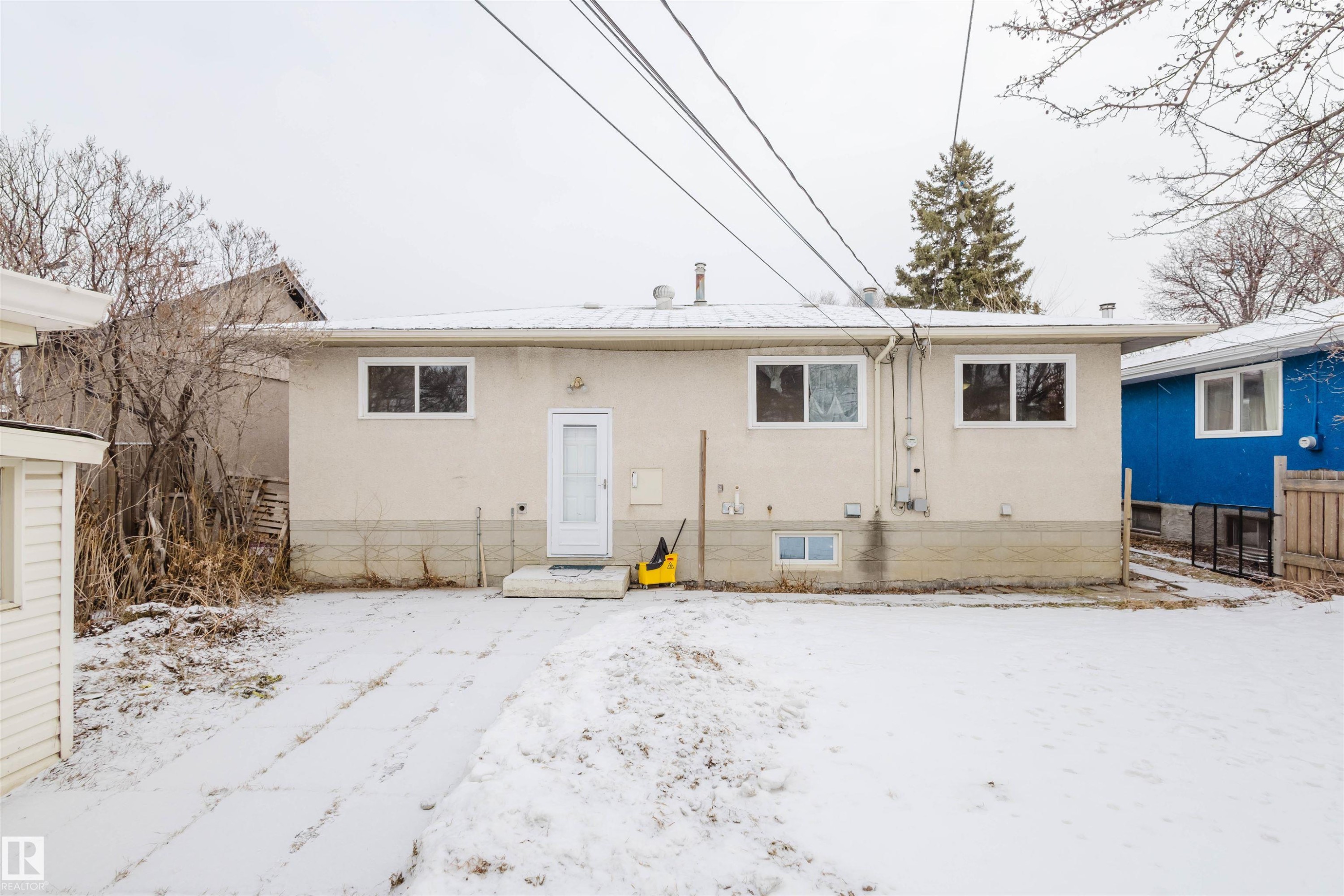 Snow covered property featuring stucco siding - 6048 105B Street Nw, Edmonton, AB - Outdoor