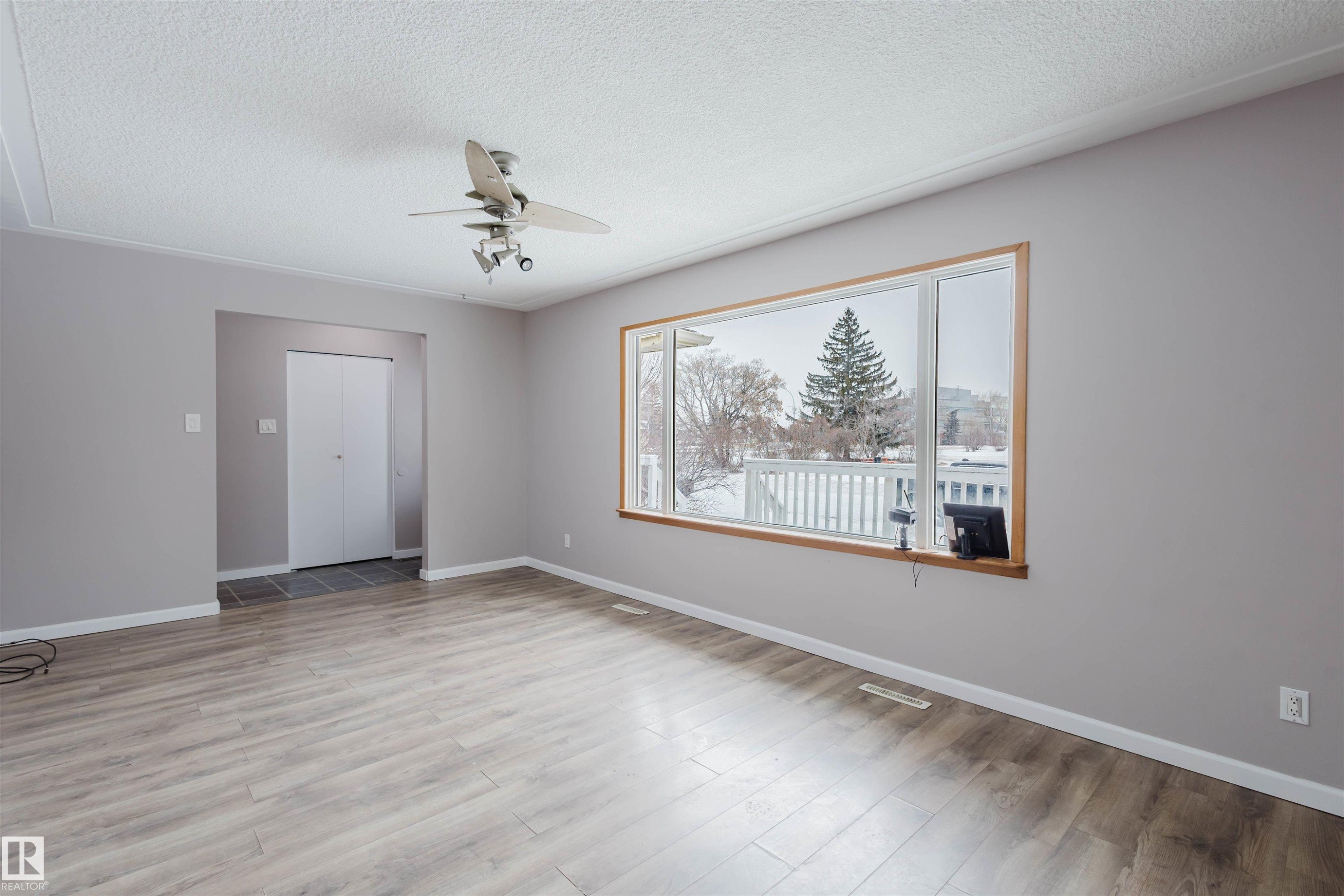 Empty room featuring ceiling fan, a textured ceiling, and light wood finished floors - 6048 105B Street Nw, Edmonton, AB - Indoor Photo Showing Other Room