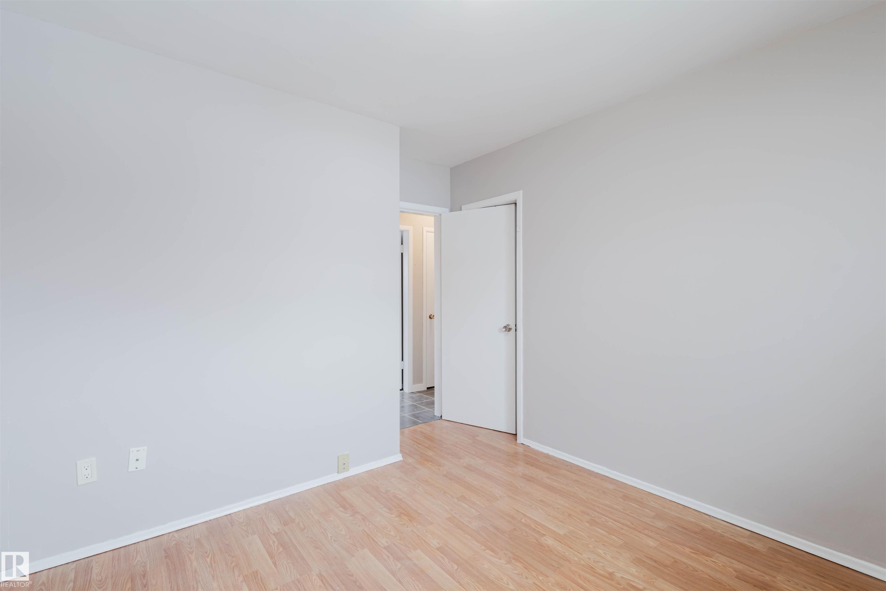 Unfurnished room featuring light wood-style floors and baseboards - 6048 105B Street Nw, Edmonton, AB - Indoor Photo Showing Other Room
