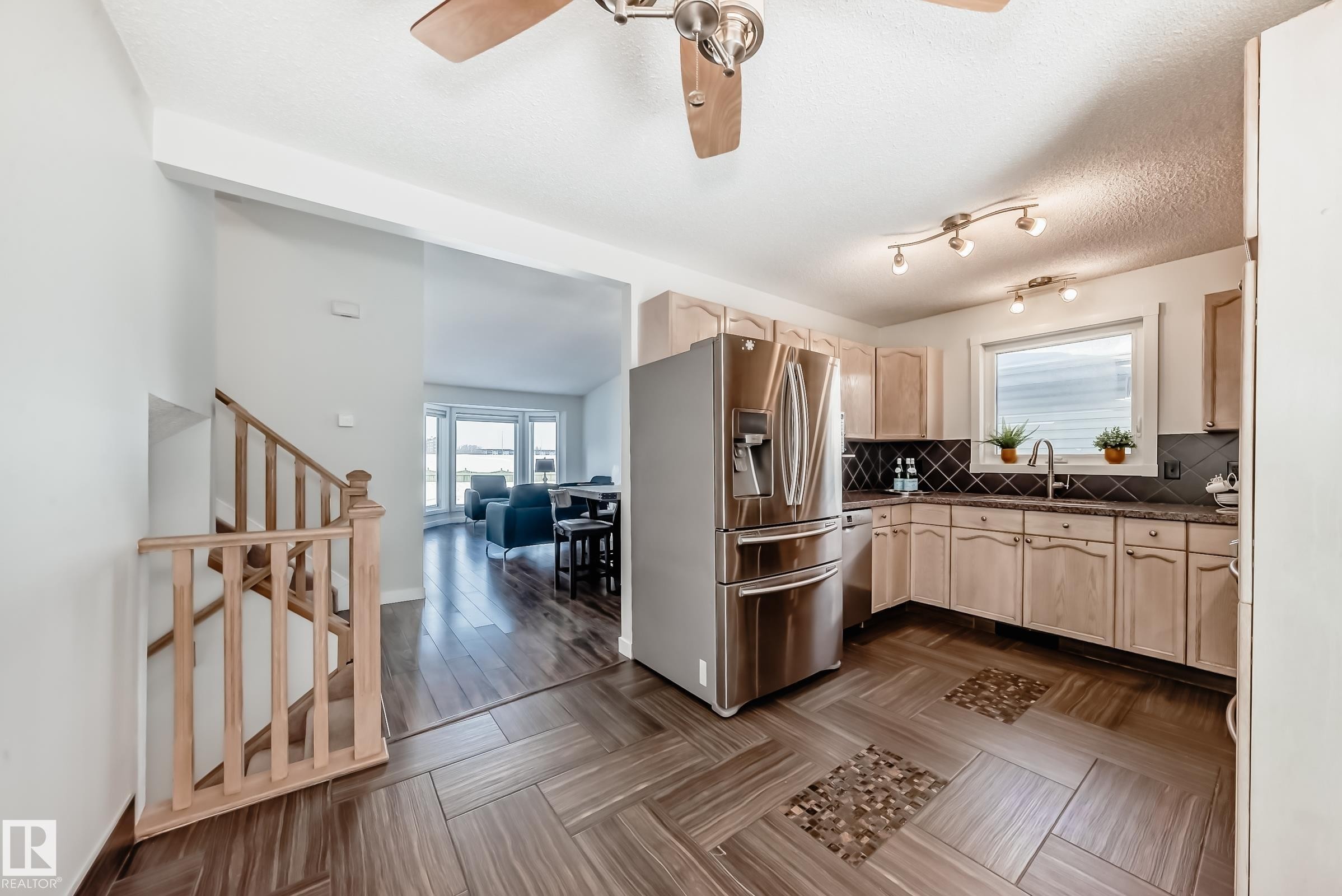 Kitchen with stainless steel appliances, light wood finish cabinetry, a ceiling fan, and a textured ceiling - 7011 190B Street, Edmonton, AB - Indoor Photo Showing Kitchen