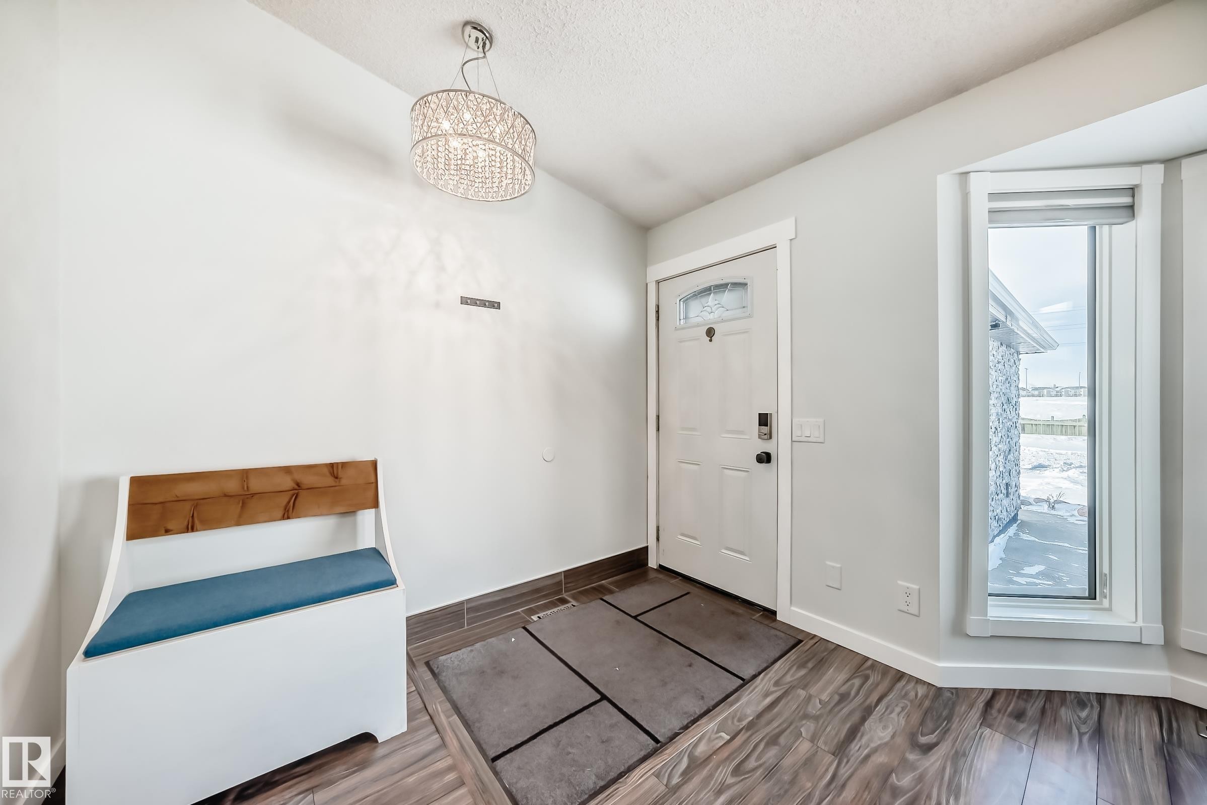 Foyer entrance featuring wood finish floors and a chandelier - 7011 190B Street, Edmonton, AB - Indoor Photo Showing Other Room
