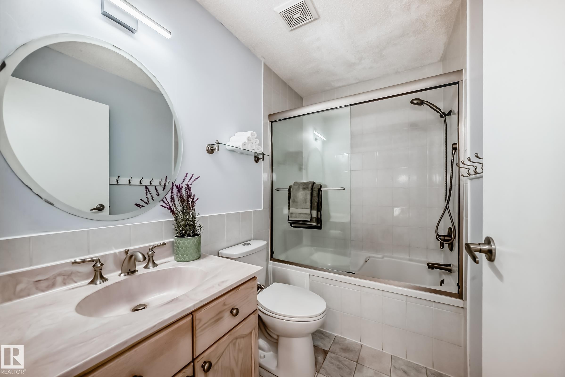 Bathroom with tiled shower / bath, vanity, and light tile patterned flooring - 7011 190B Street, Edmonton, AB - Indoor Photo Showing Bathroom