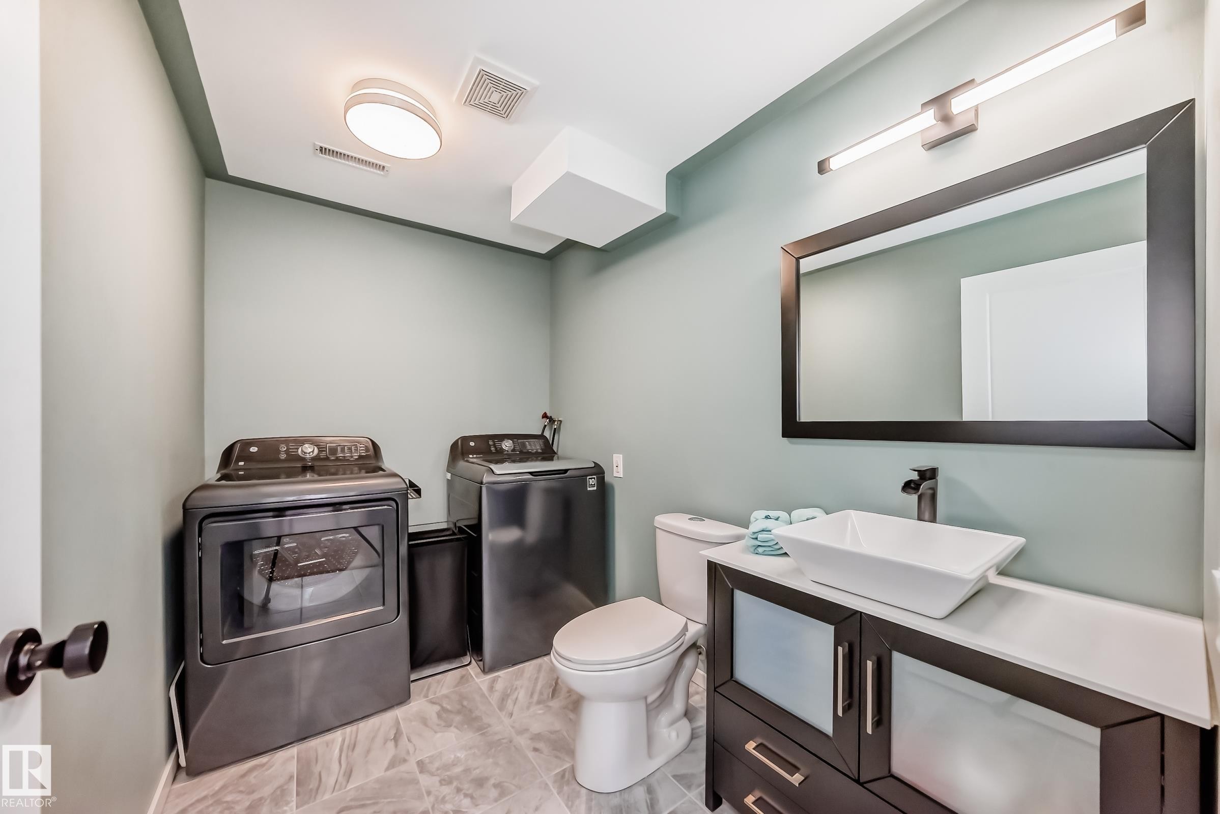 Half bathroom featuring vanity and washing machine and clothes dryer - 7011 190B Street, Edmonton, AB - Indoor Photo Showing Laundry Room