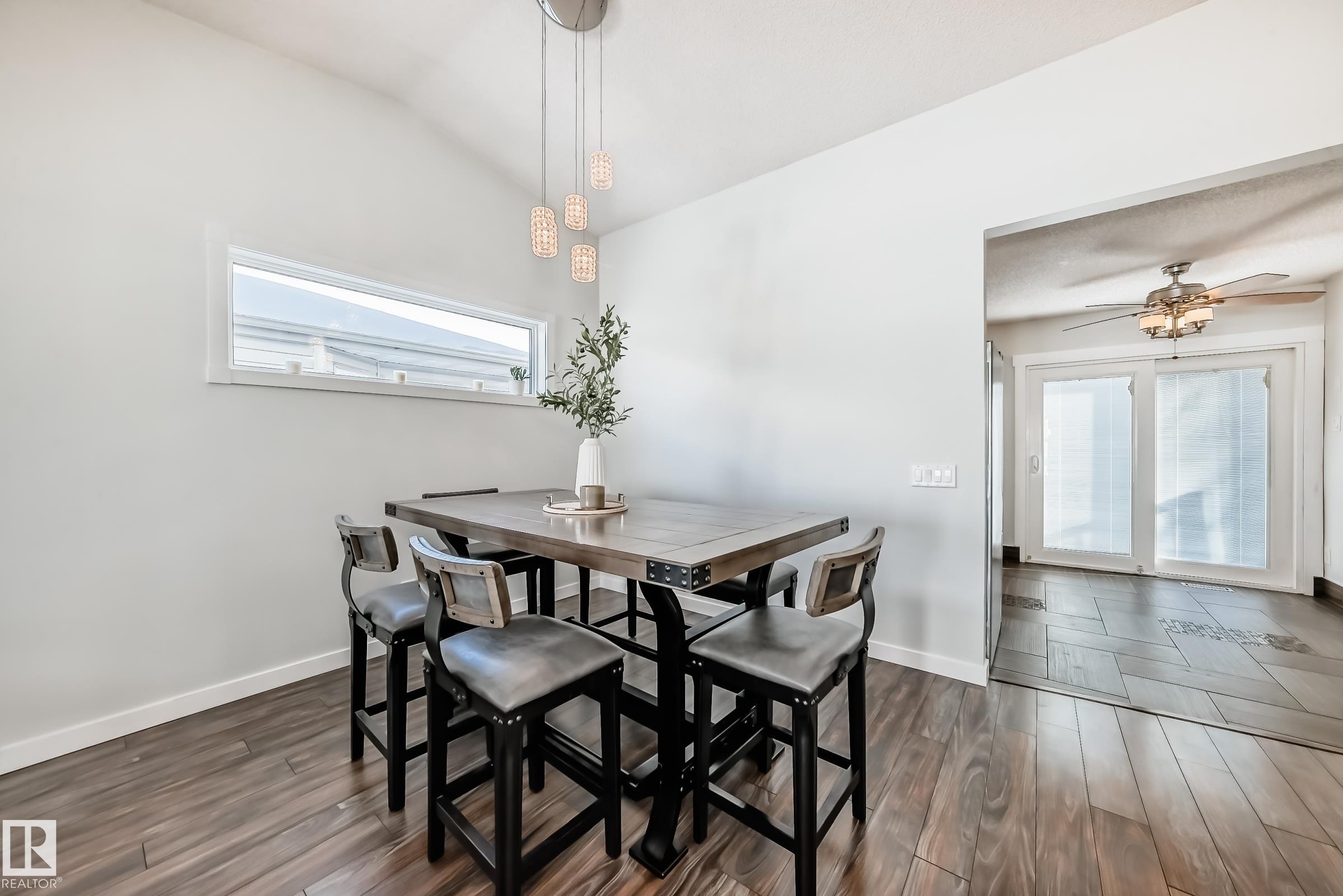 Dining space featuring dark wood-type flooring, lofted ceiling, and a ceiling fan - 7011 190B Street, Edmonton, AB - Indoor Photo Showing Dining Room