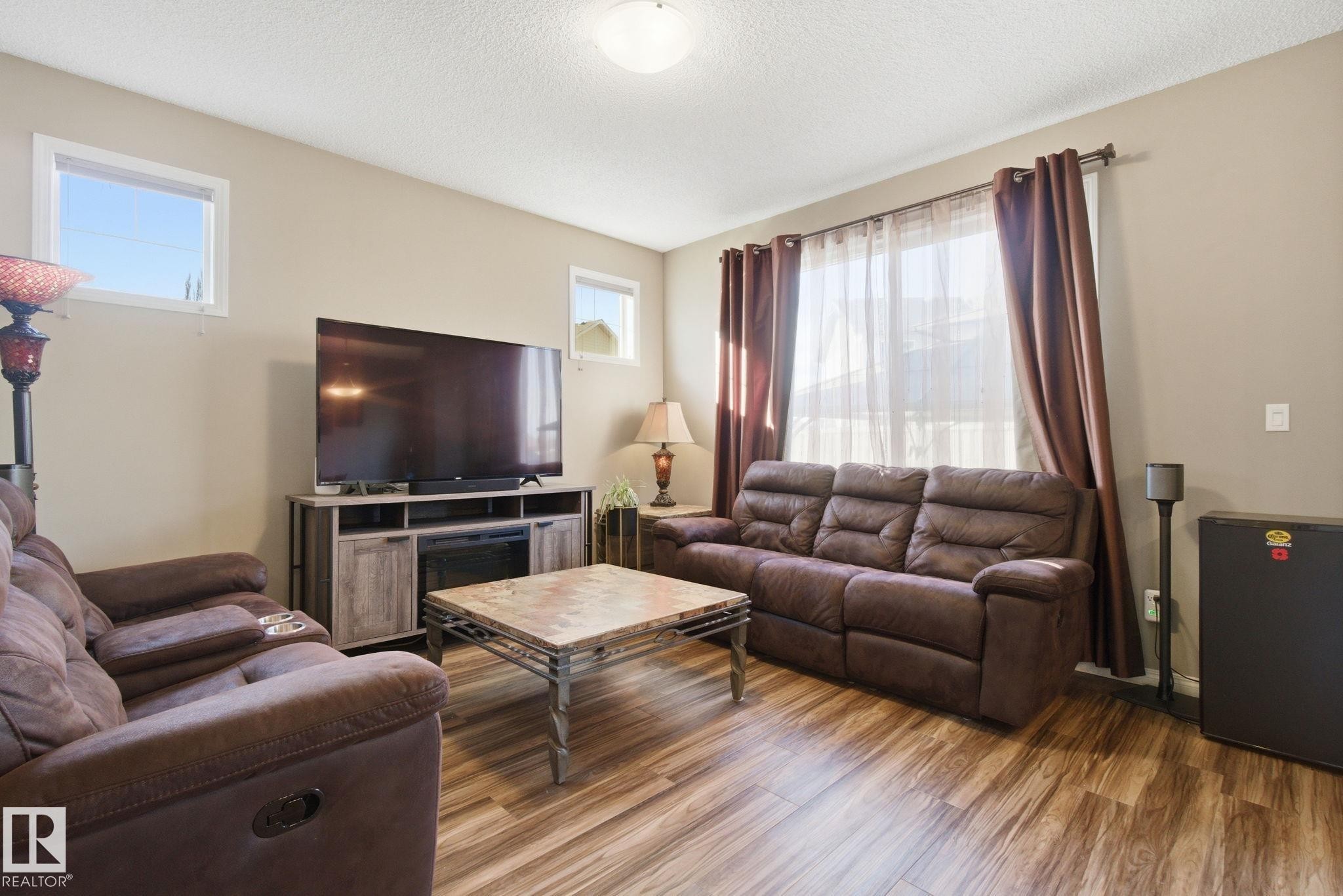 Living room featuring light wood-style flooring and a textured ceiling - 3087 Arthurs Crescent, Edmonton, AB - Indoor Photo Showing Living Room
