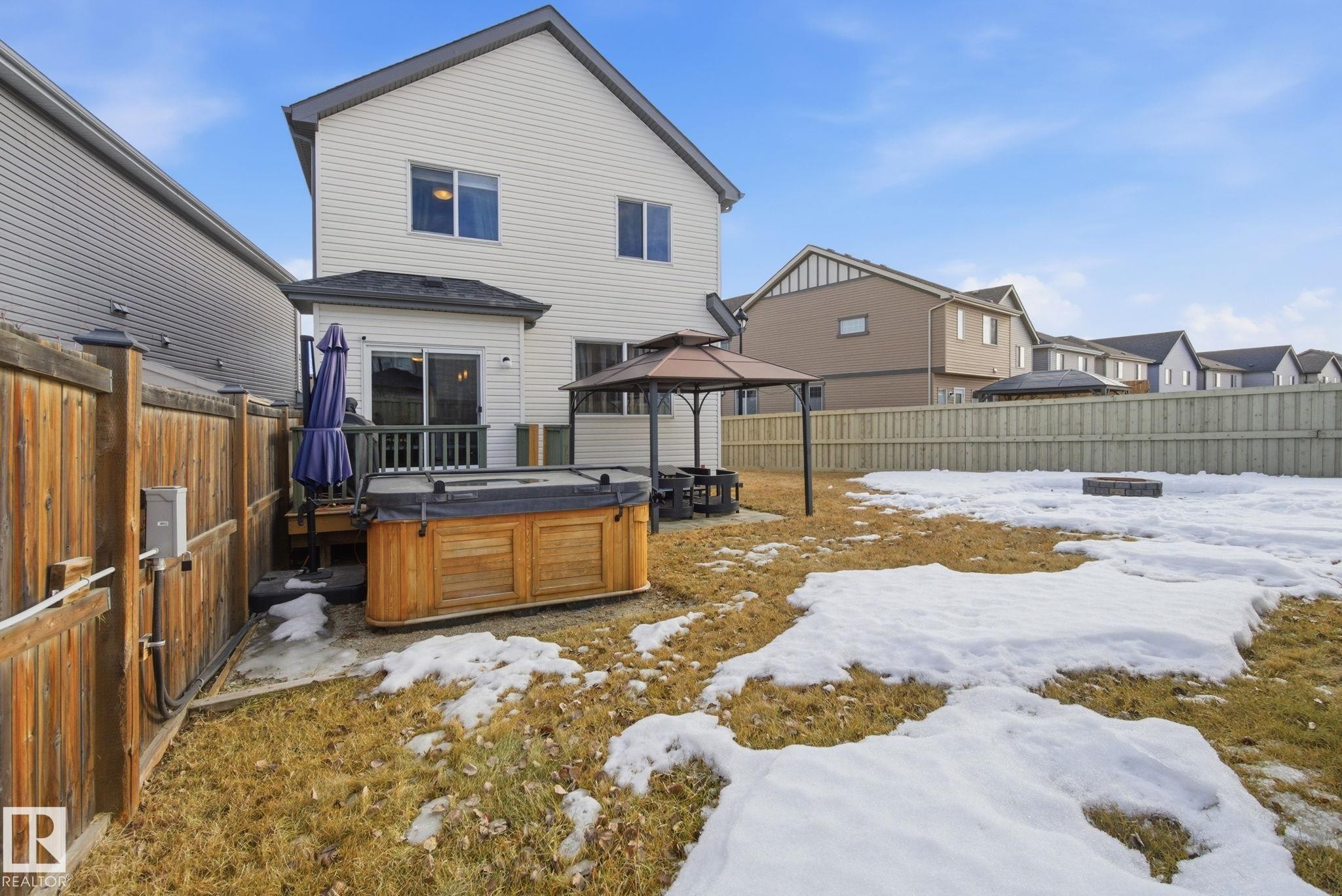 Snow covered property with a gazebo, a residential view, a fenced backyard, and a hot tub - 3087 Arthurs Crescent, Edmonton, AB - Outdoor