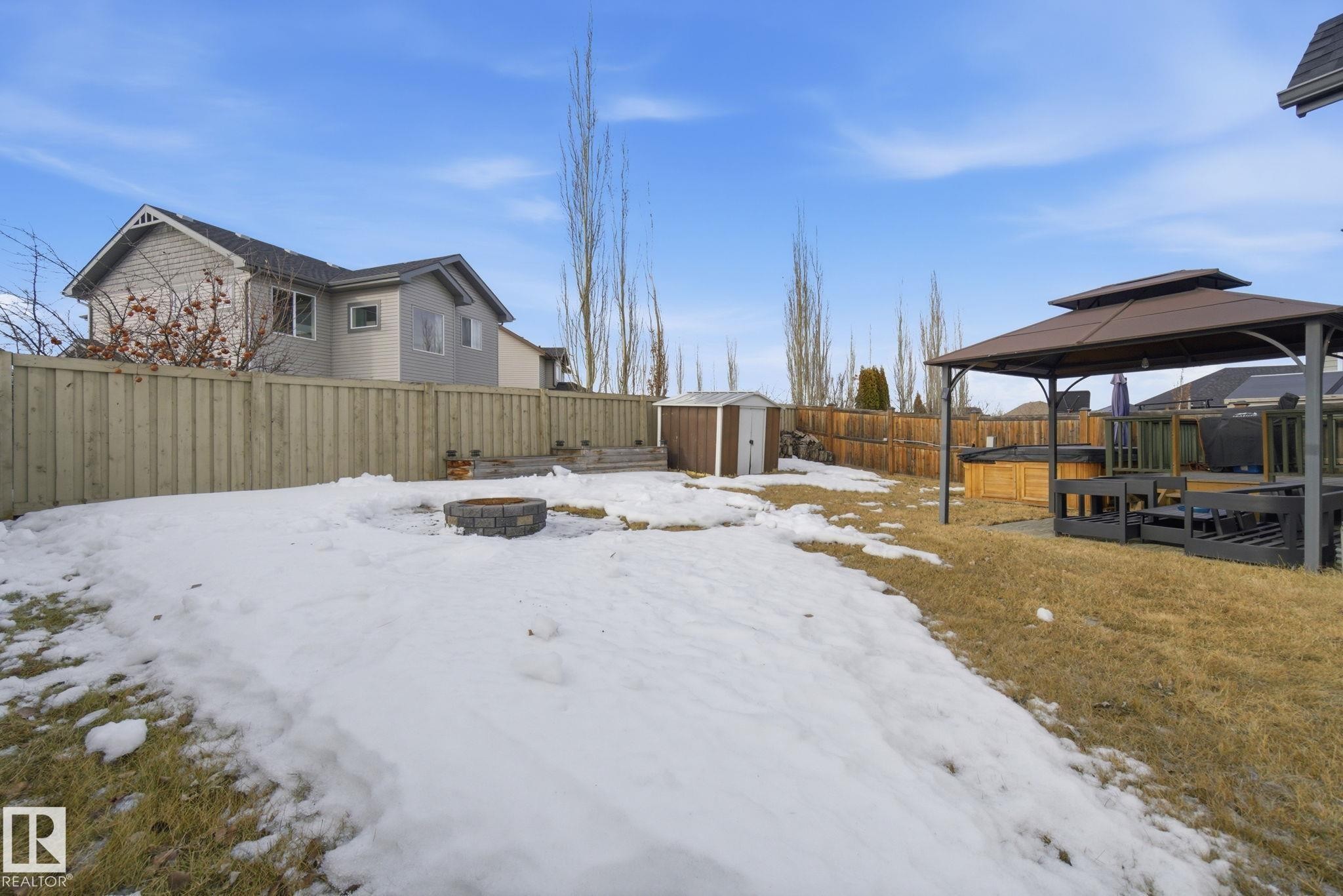 Yard covered in snow with a fire pit, a fenced backyard, and a shed - 3087 Arthurs Crescent, Edmonton, AB - Outdoor With Deck Patio Veranda