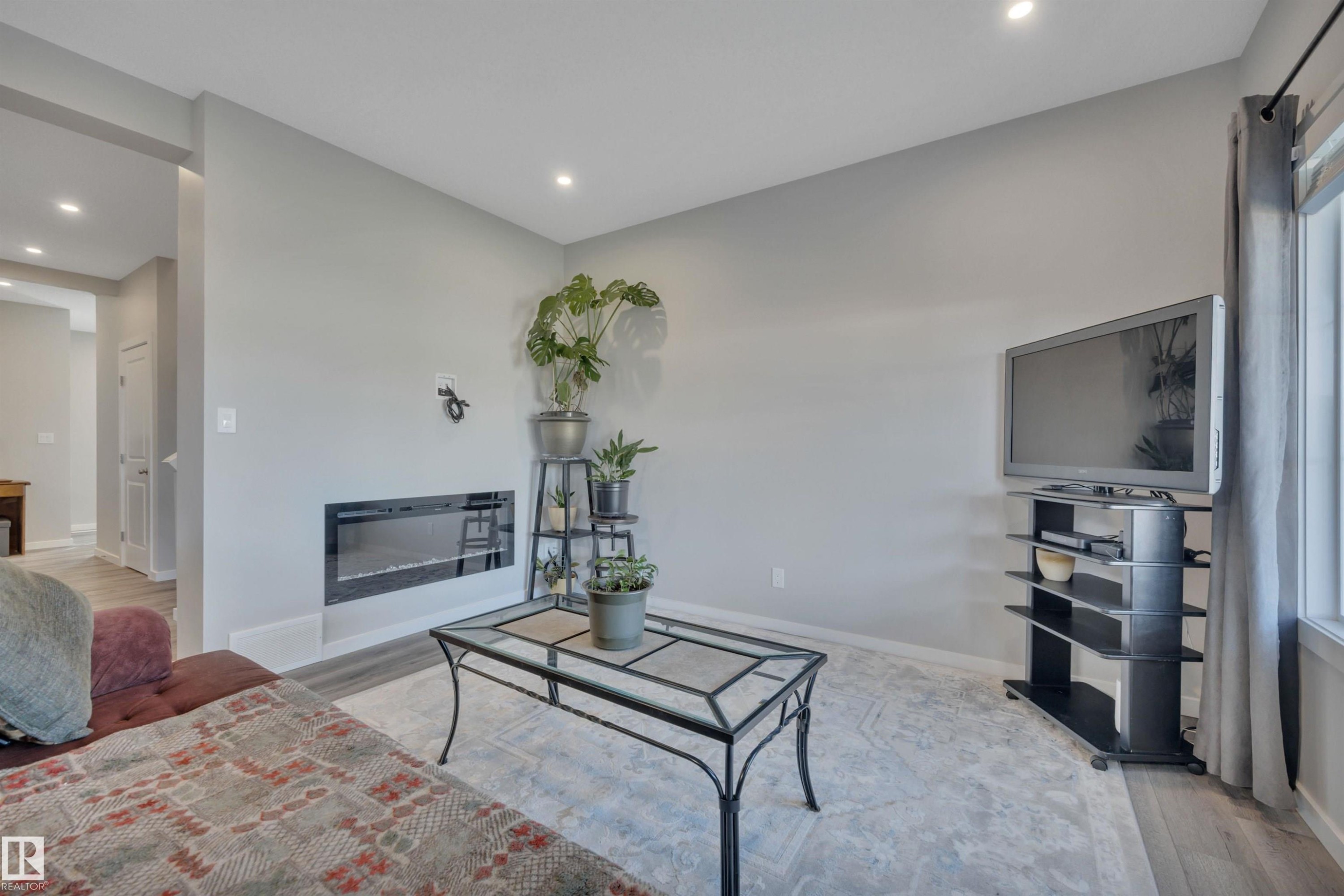 Living room with light wood-style flooring and recessed lighting - 157 Larch Crescent, Leduc, AB - Indoor Photo Showing Living Room With Fireplace
