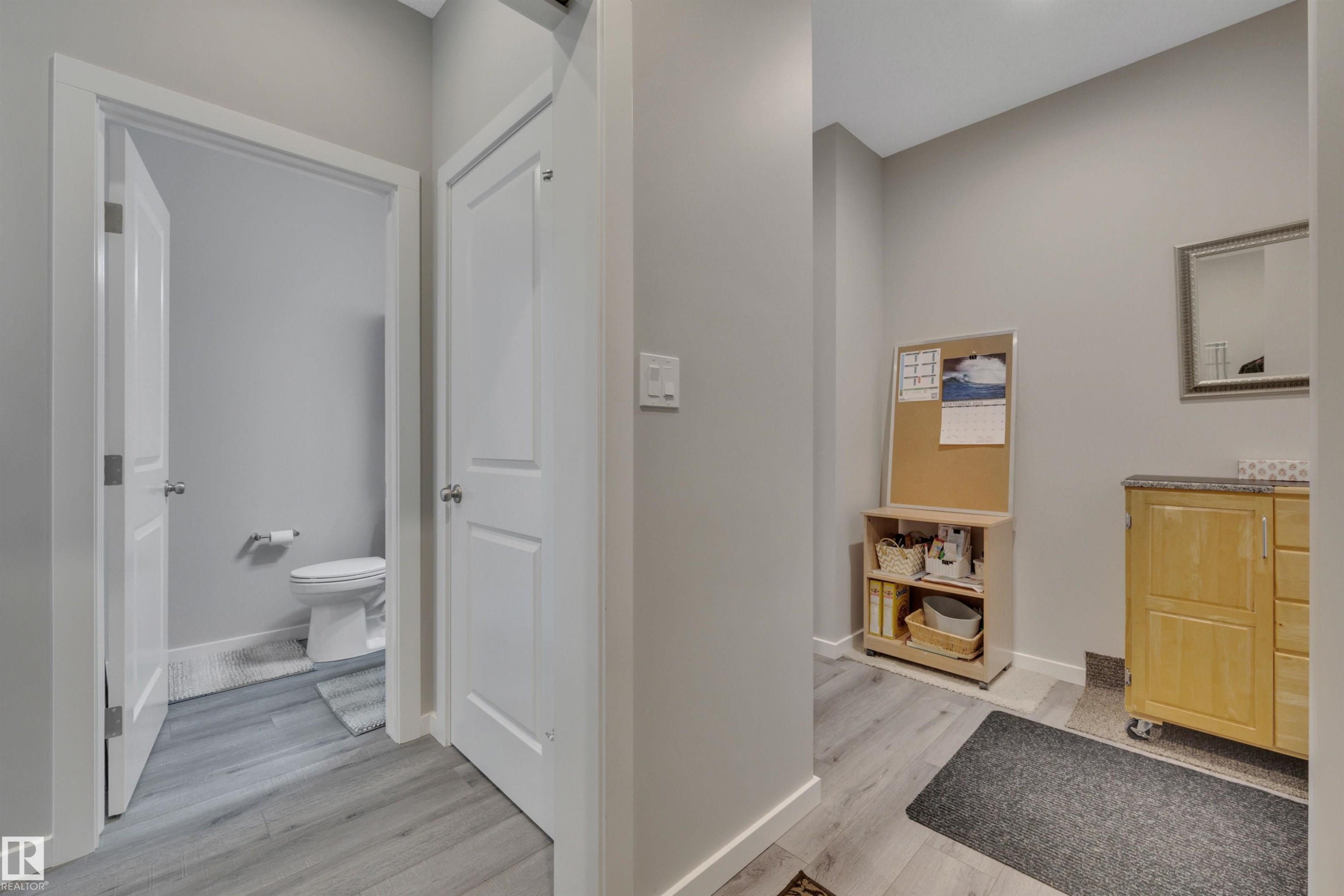 Corridor with light wood-style flooring and baseboards - 157 Larch Crescent, Leduc, AB - Indoor
