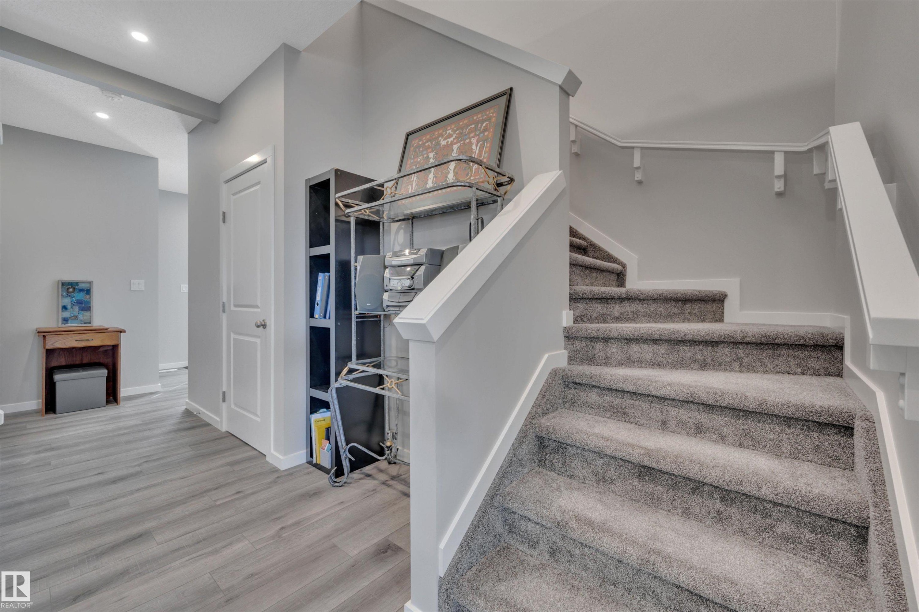 Staircase featuring wood finished floors and recessed lighting - 157 Larch Crescent, Leduc, AB - Indoor Photo Showing Other Room