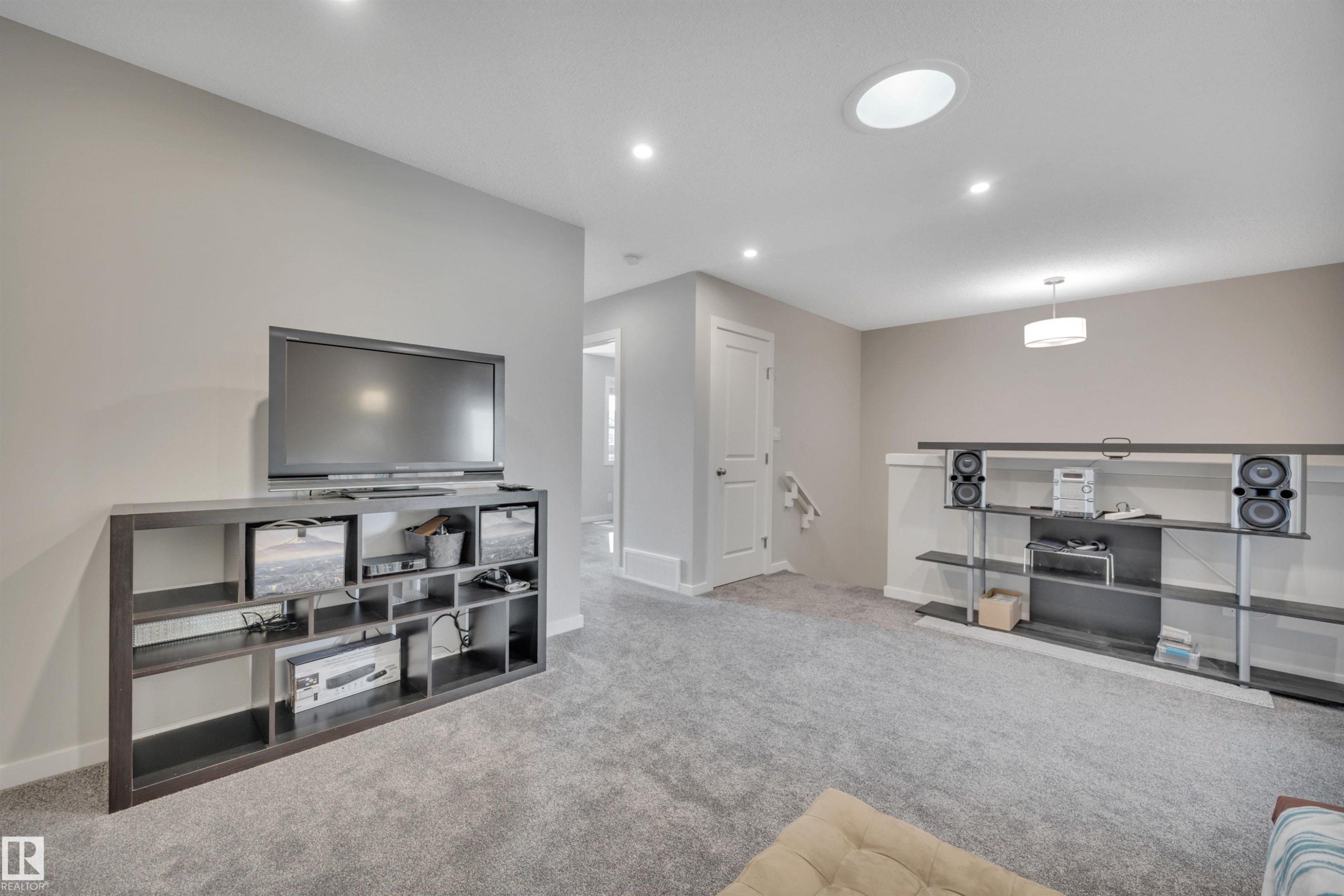 Living room with light carpet and recessed lighting - 157 Larch Crescent, Leduc, AB - Indoor