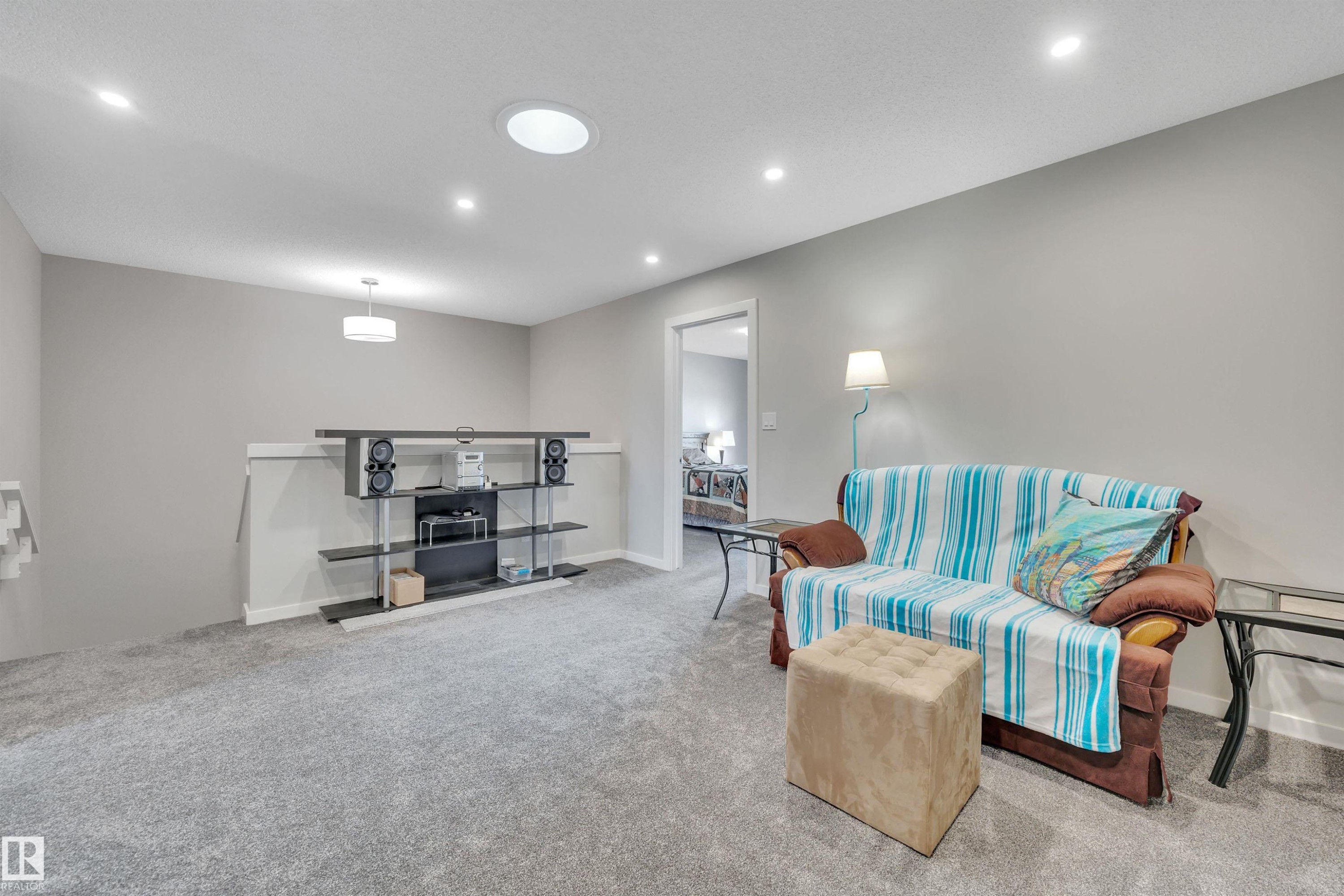 Living room with light colored carpet and recessed lighting - 157 Larch Crescent, Leduc, AB - Indoor