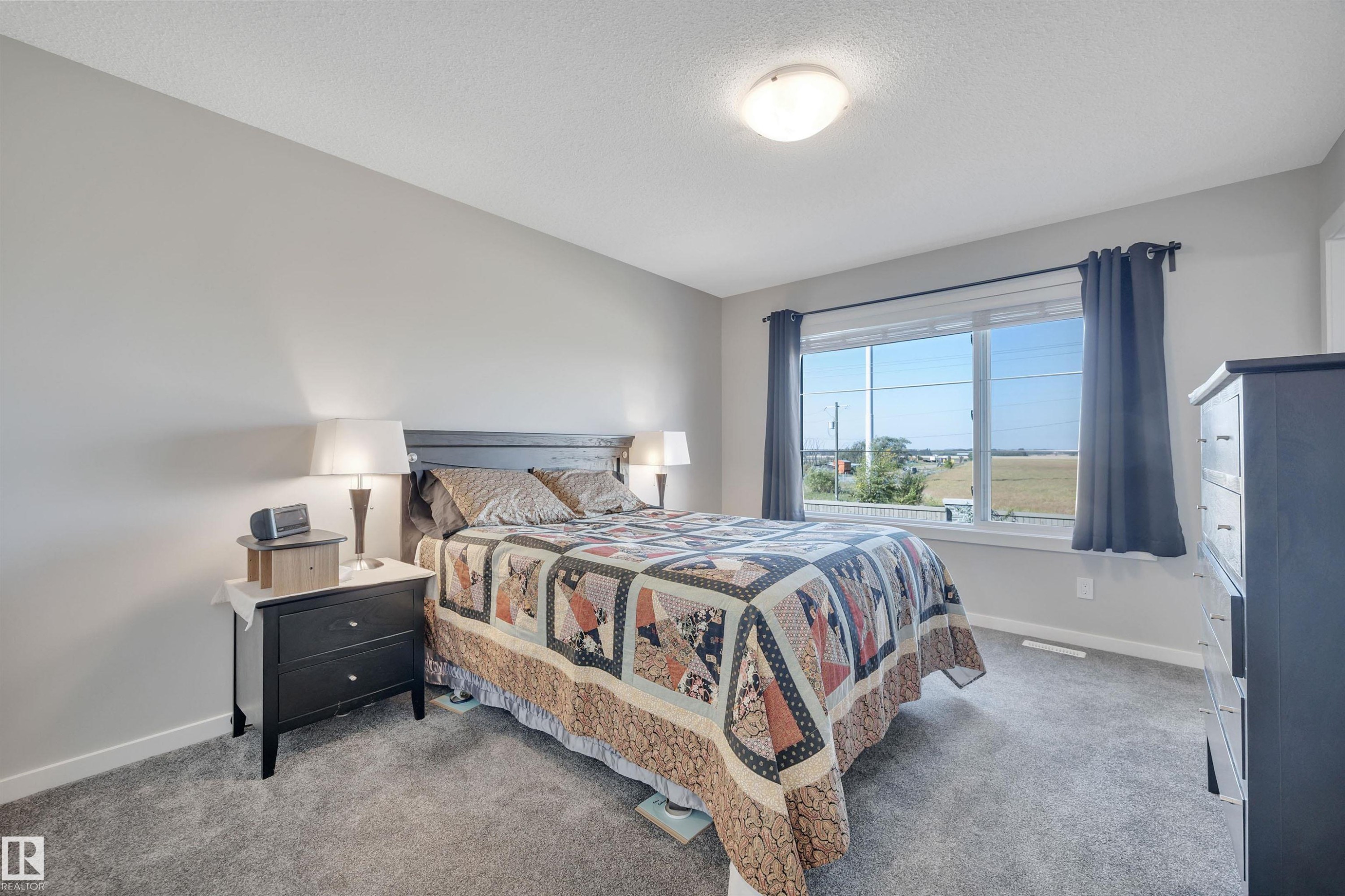 Bedroom with carpet and a textured ceiling - 157 Larch Crescent, Leduc, AB - Indoor Photo Showing Bedroom