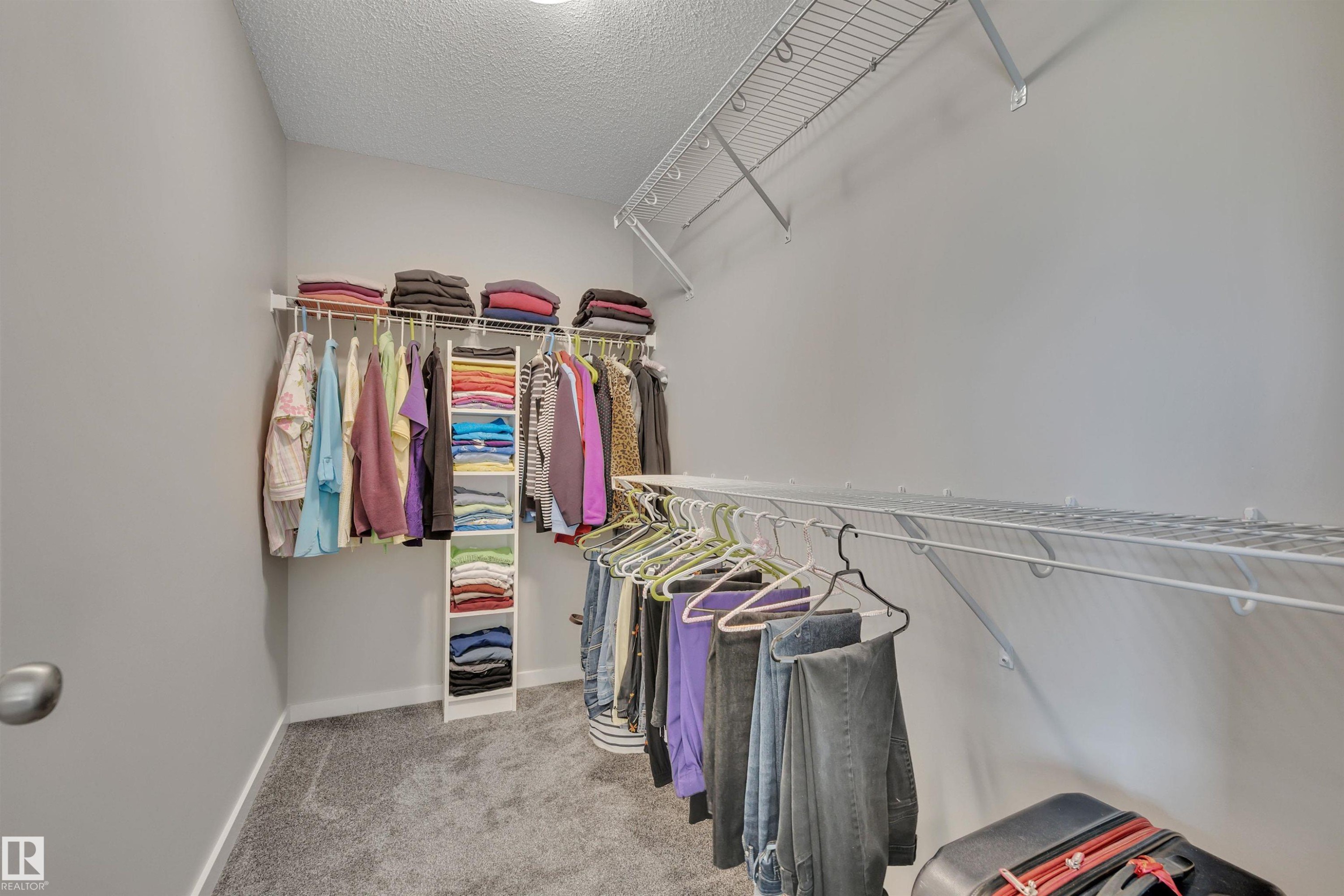 Walk in closet with light carpet - 157 Larch Crescent, Leduc, AB - Indoor With Storage
